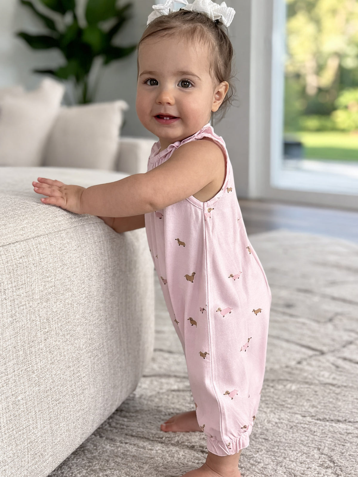 Girls' pink dog-print sleeveless romper with ruffled shoulder trim and gathered cuffs