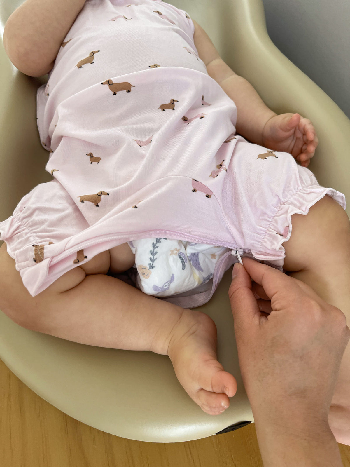 Pink dog-print bubble romper close-up with gathered leg hem and ruffle edge