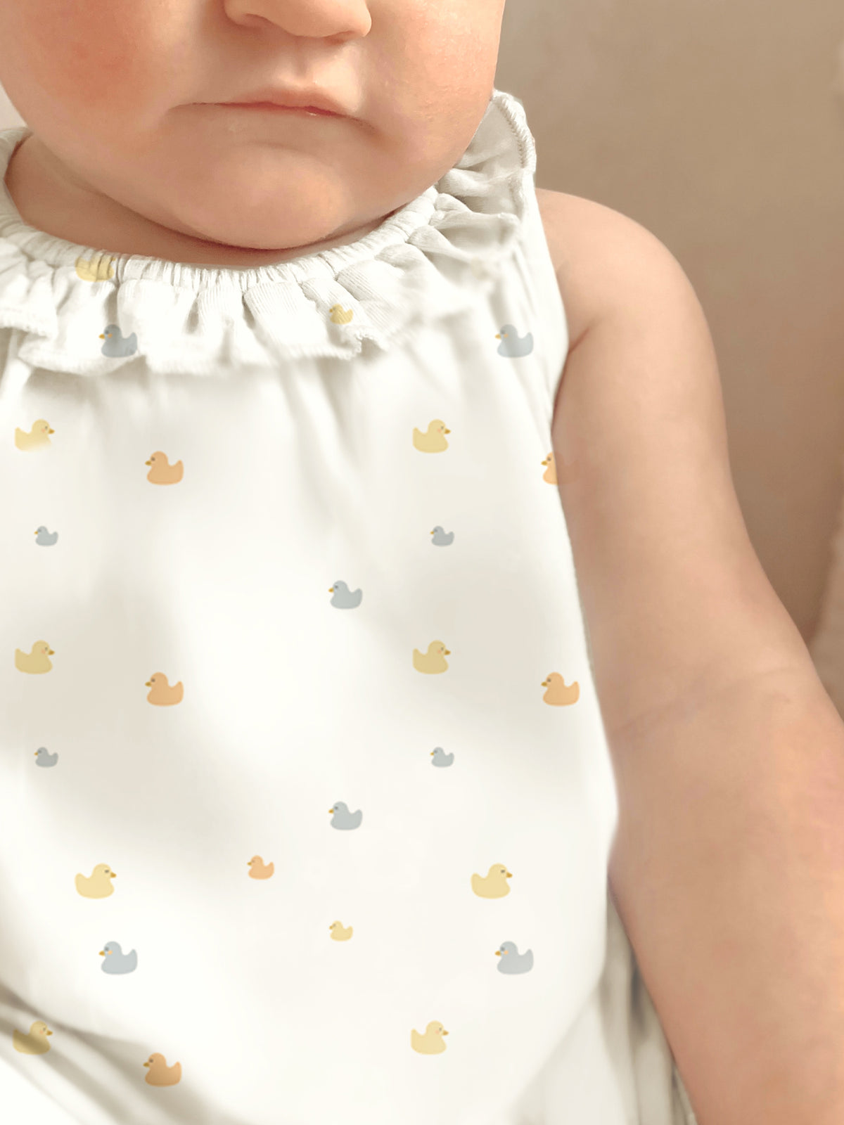 Cream duck-print sleeveless romper with ruffled collar