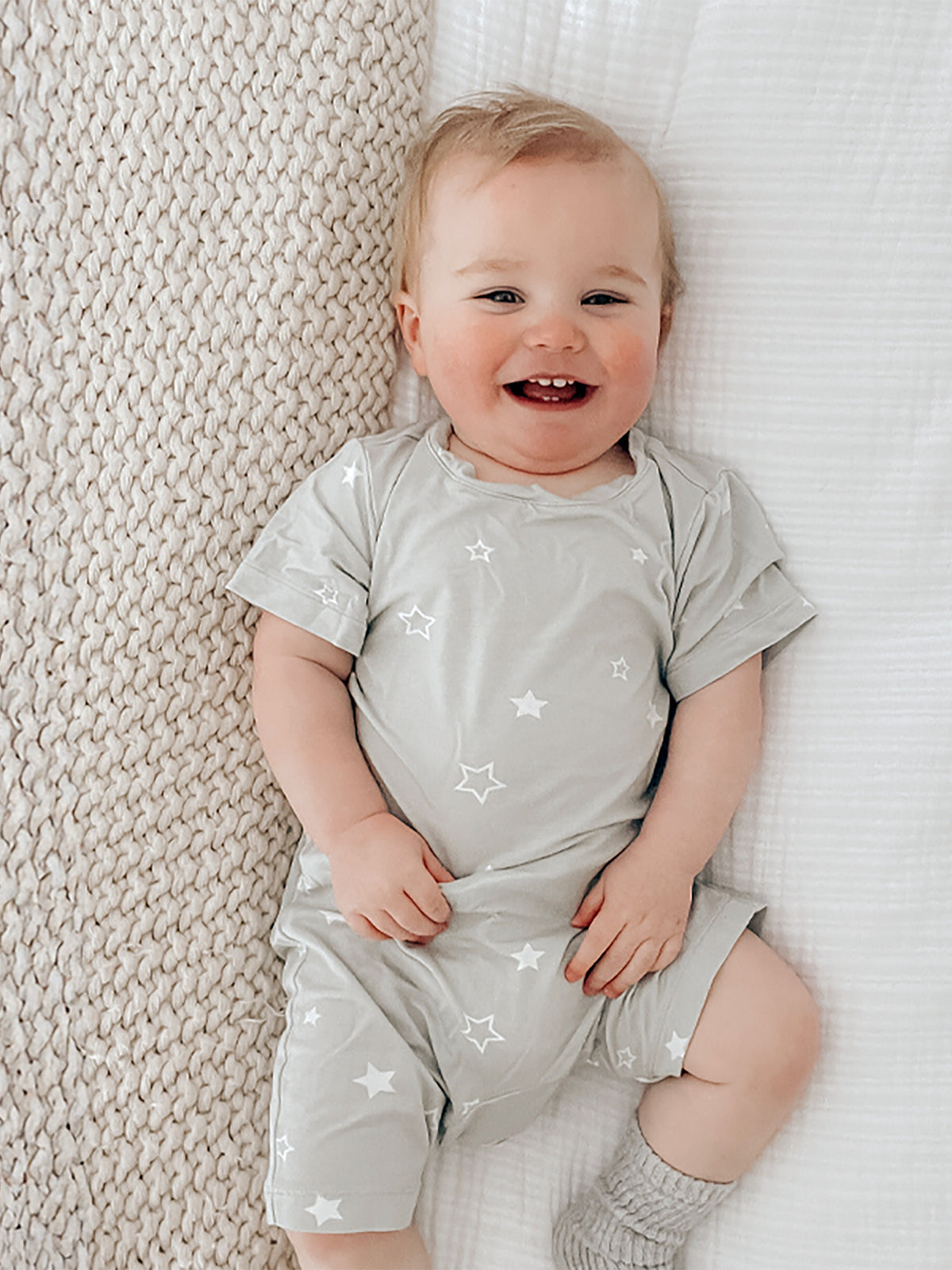 Light sage gray shortie romper with white star pattern, short sleeves and leg openings