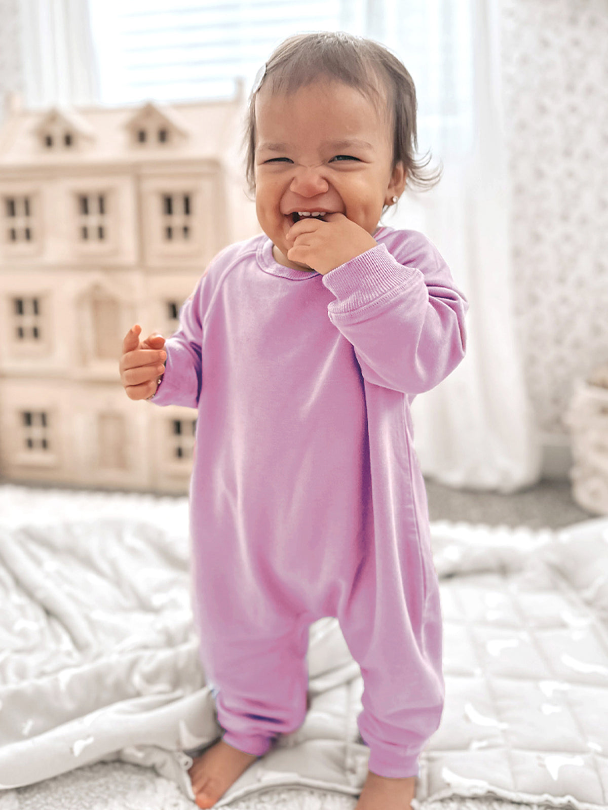 Lilac long-sleeve cotton jumpsuit on smiling toddler, ribbed cuffs and crew neckline