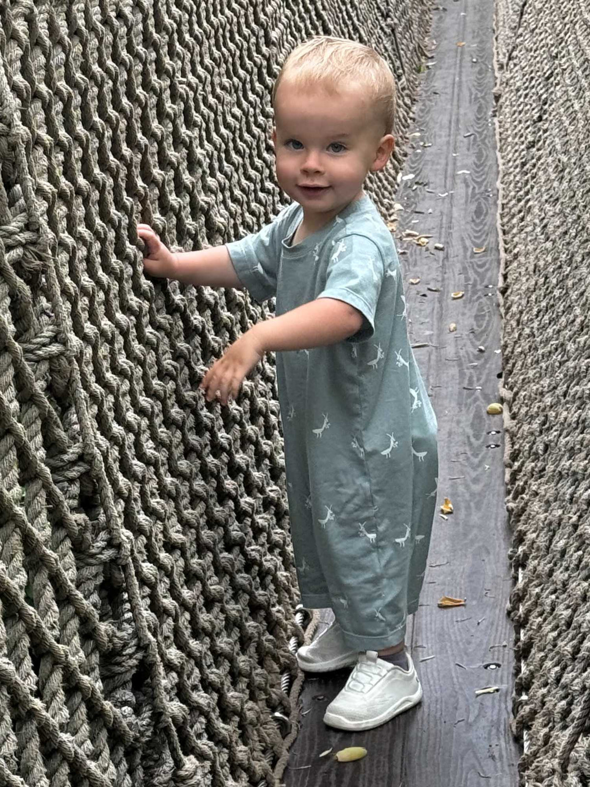 Sage green cotton short romper with white animal prints, short sleeves and legs