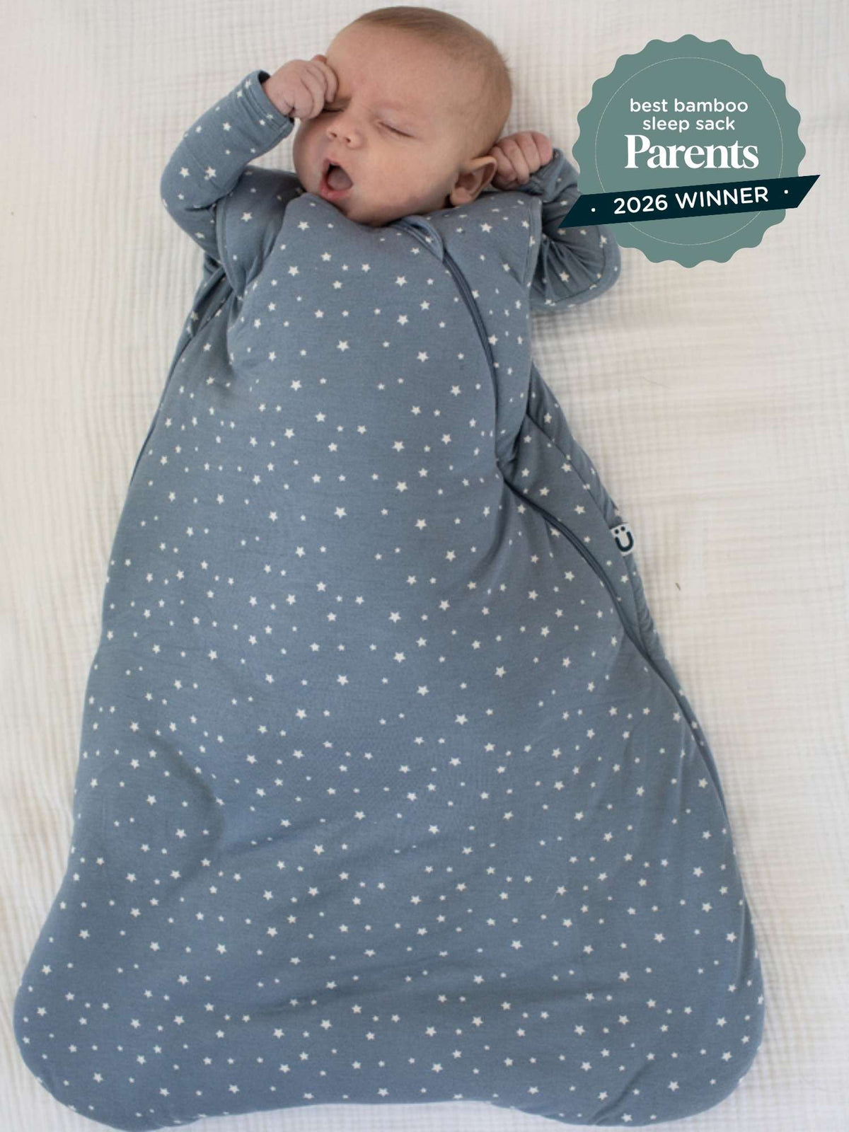 Baby in blue 2.5 TOG sleep sack with white star print and gray sleeves