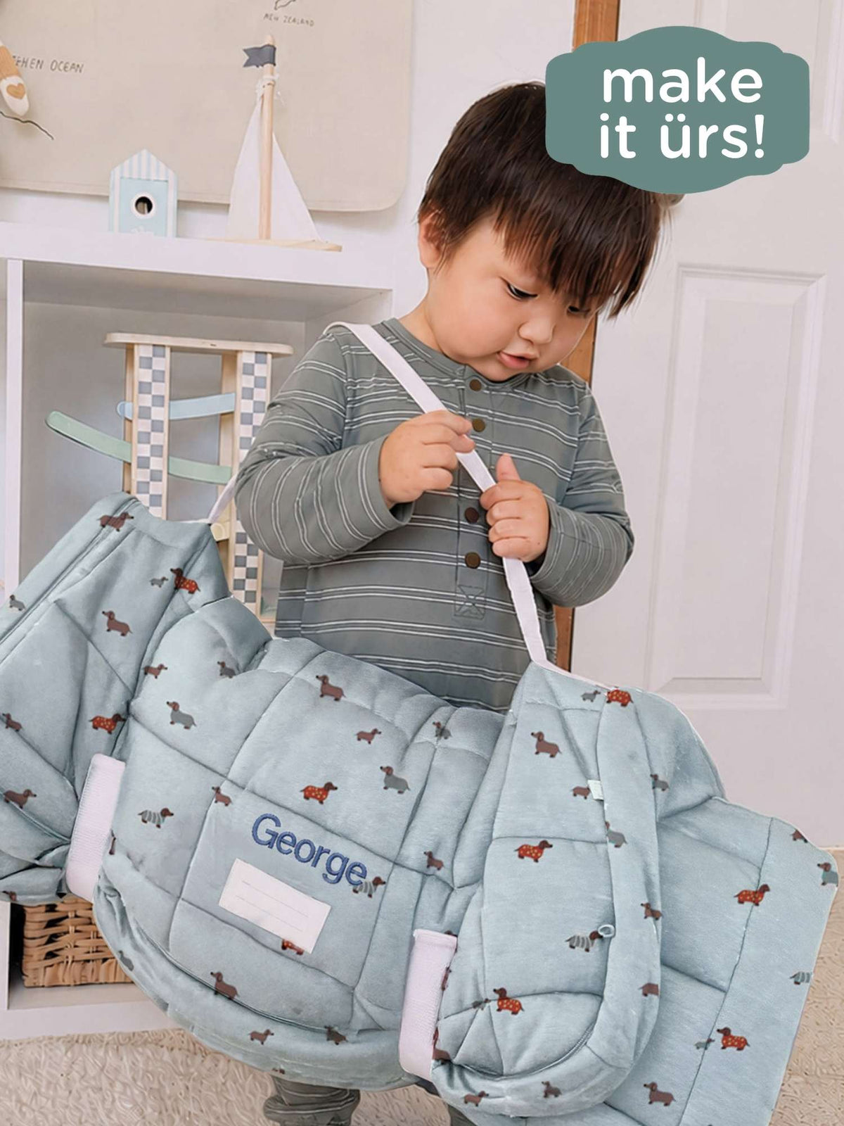 Light blue dog-print nap mat held by child with fabric name tag