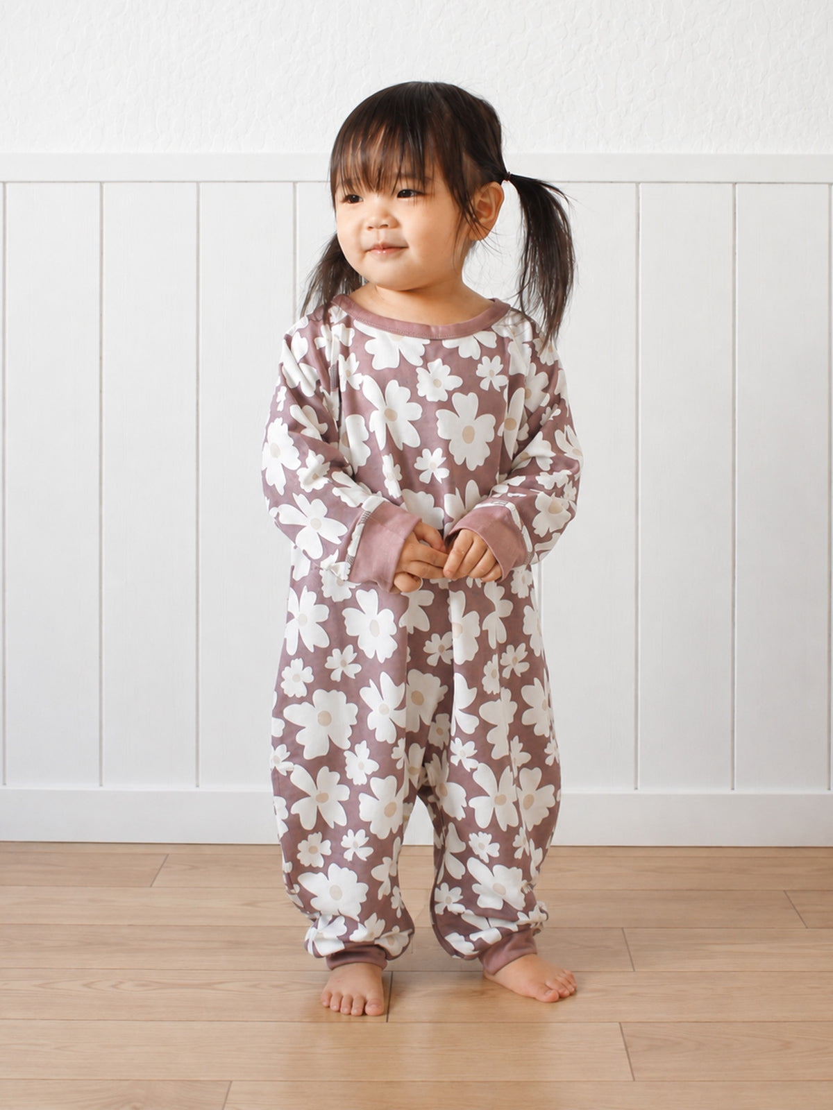 Purple fleece jumpsuit with white daisy print, long sleeves and relaxed fit
