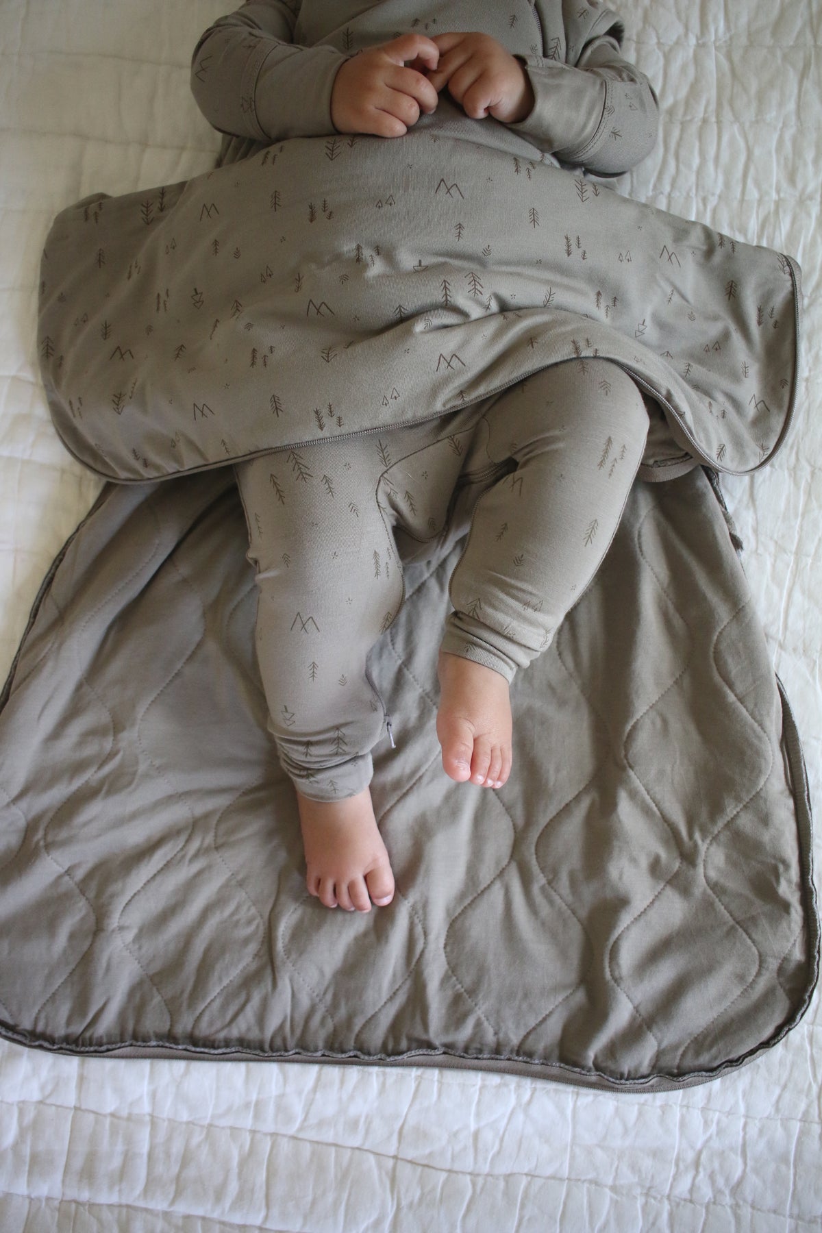 Beige sleep sack with tree print, gray-trimmed opening, and front zipper
