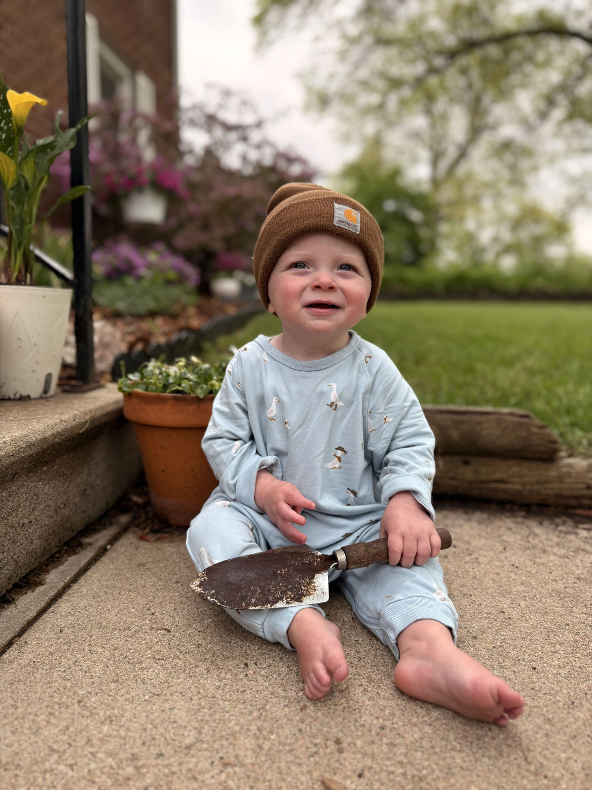 Light blue fleece jumpsuit with animal print, baby kneeling and smiling