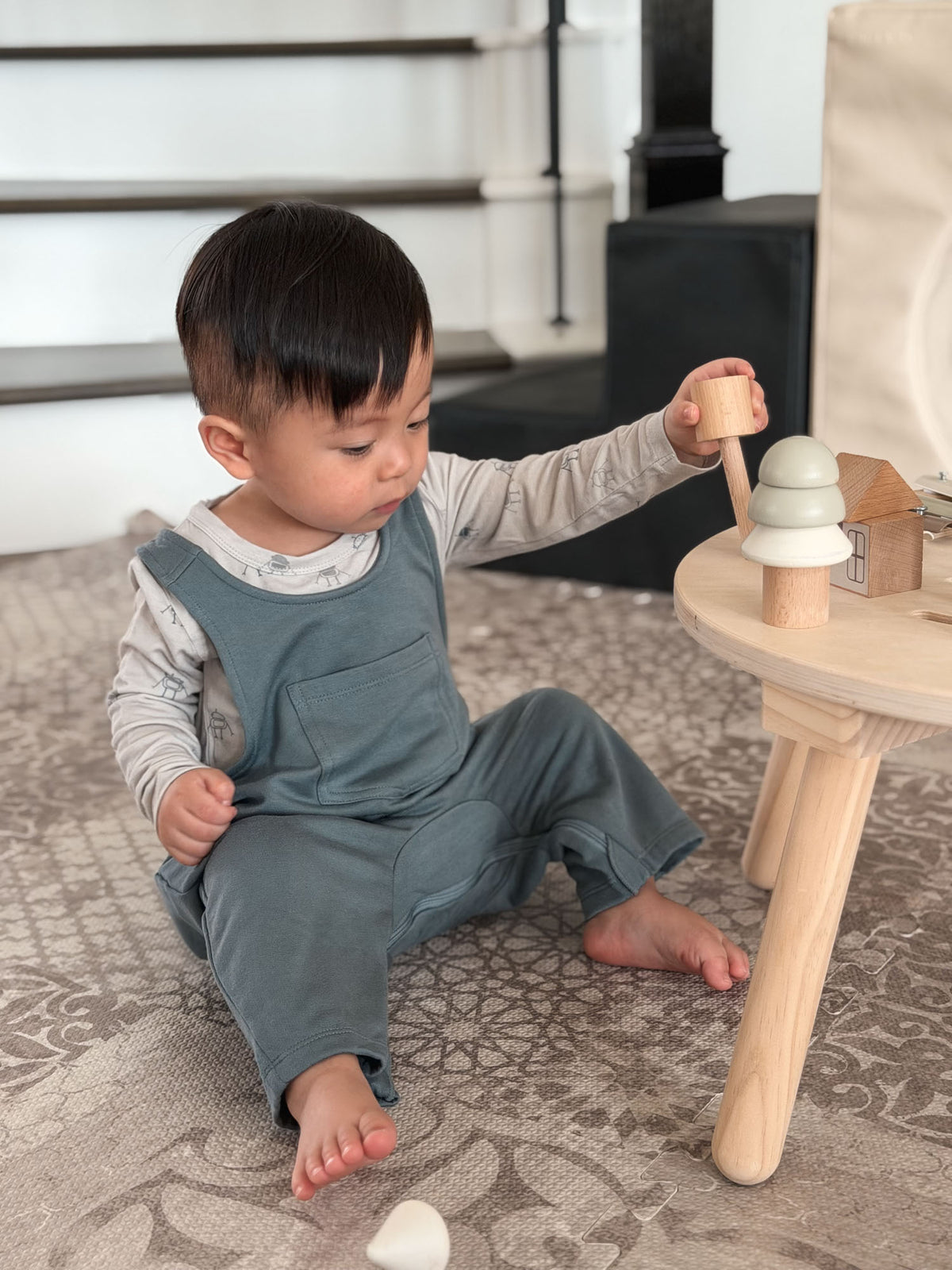 Teal fleece baby overalls while crawling, featuring a front pocket