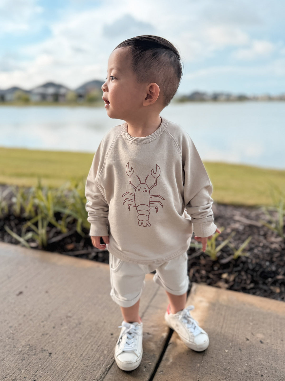 Beige crewneck sweatshirt with long sleeves and rust lobster chest graphic