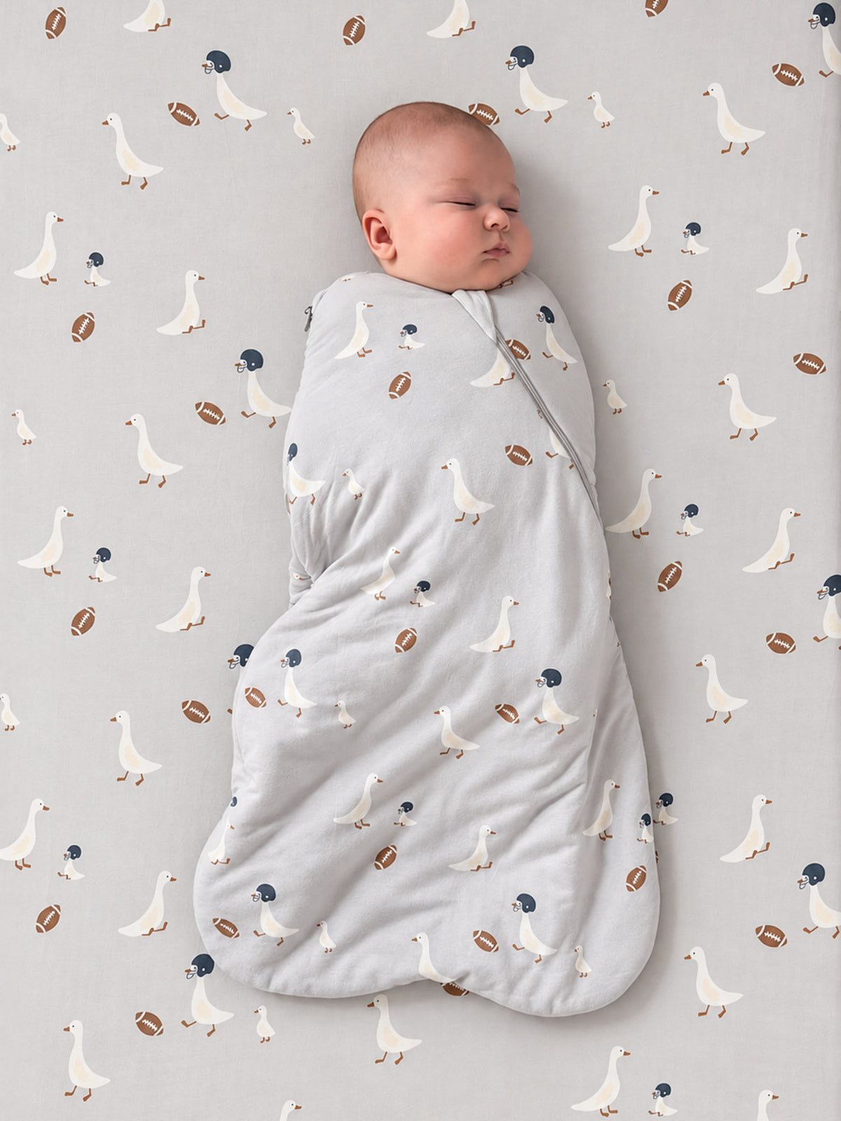 Swaddle sleep sack with football print, 2.5 TOG, light gray wrap around baby