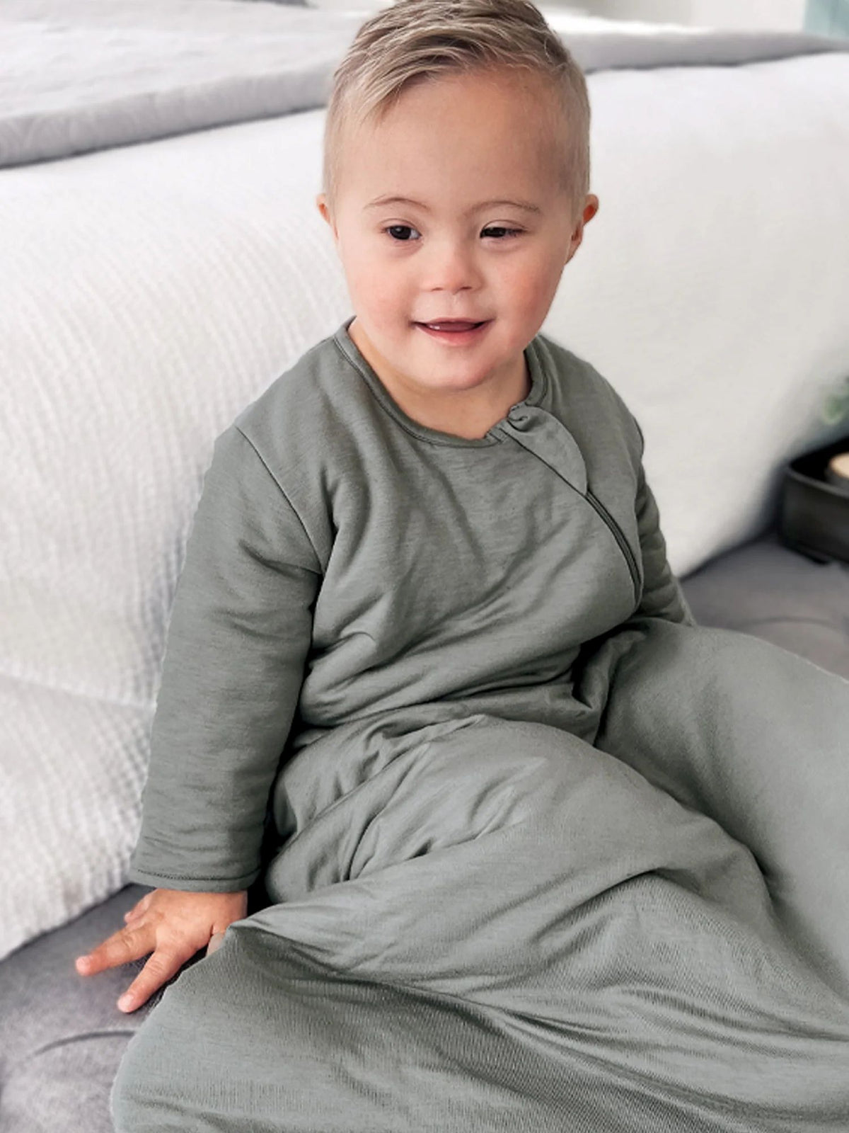Sage green long-sleeve sleep sack with front zipper, shown being worn