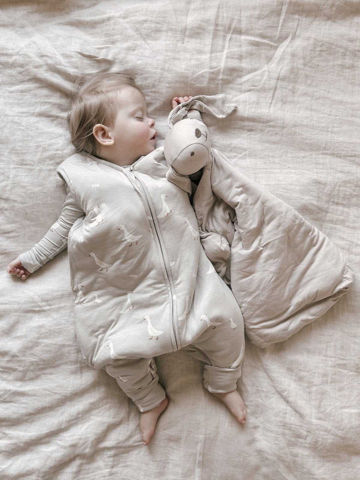 Light beige footie sleep sack with goose print, front zipper and built-in feet