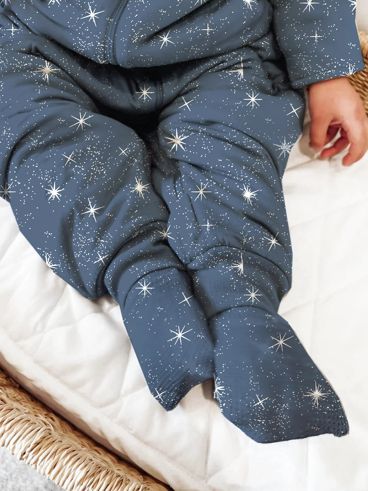 Star-print footie sleep sack legs and cuffs on white bedding