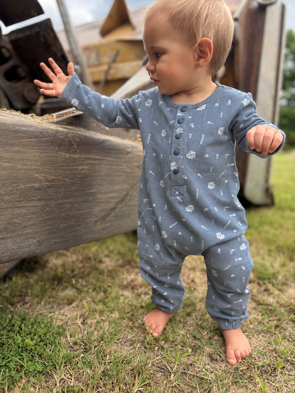 Blue tool-print henley jumpsuit with long sleeves, button-front, and cuffed legs