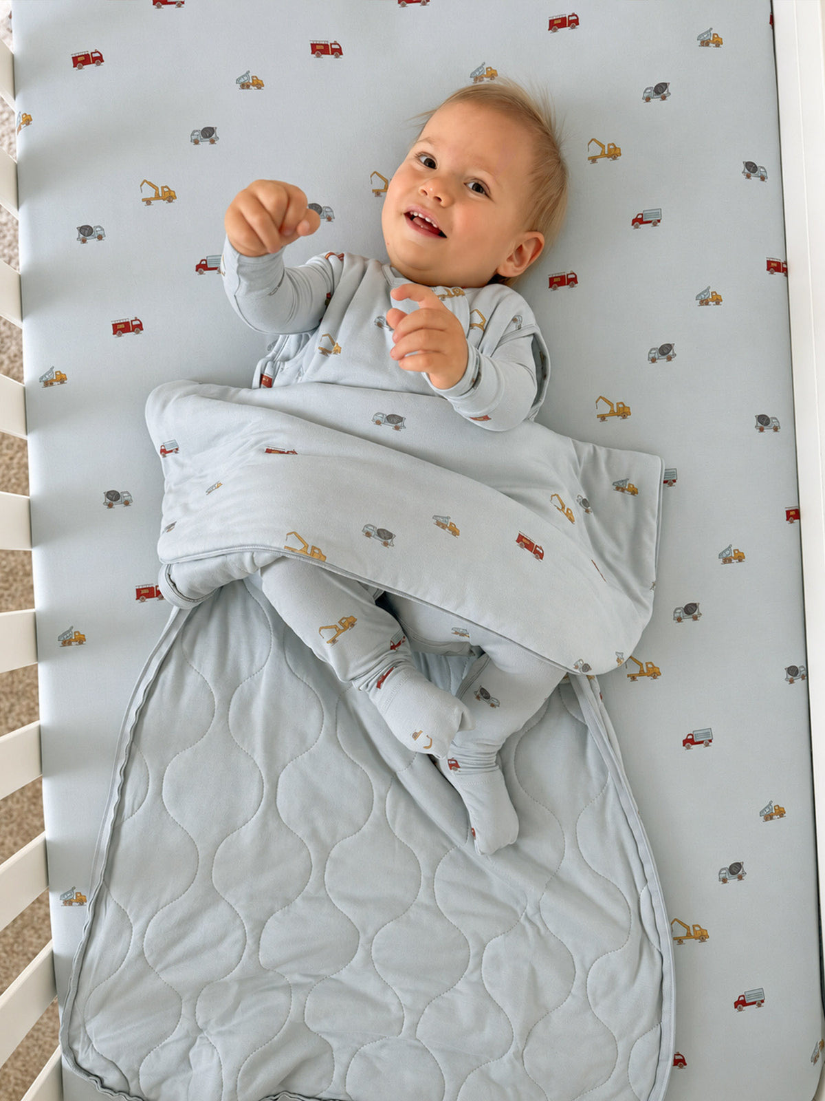 Light blue sleep sack with vehicle print, quilted footed panel and front zip