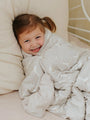 Goose-print cloud blanket, light cream with small geese pattern, wrapped around child