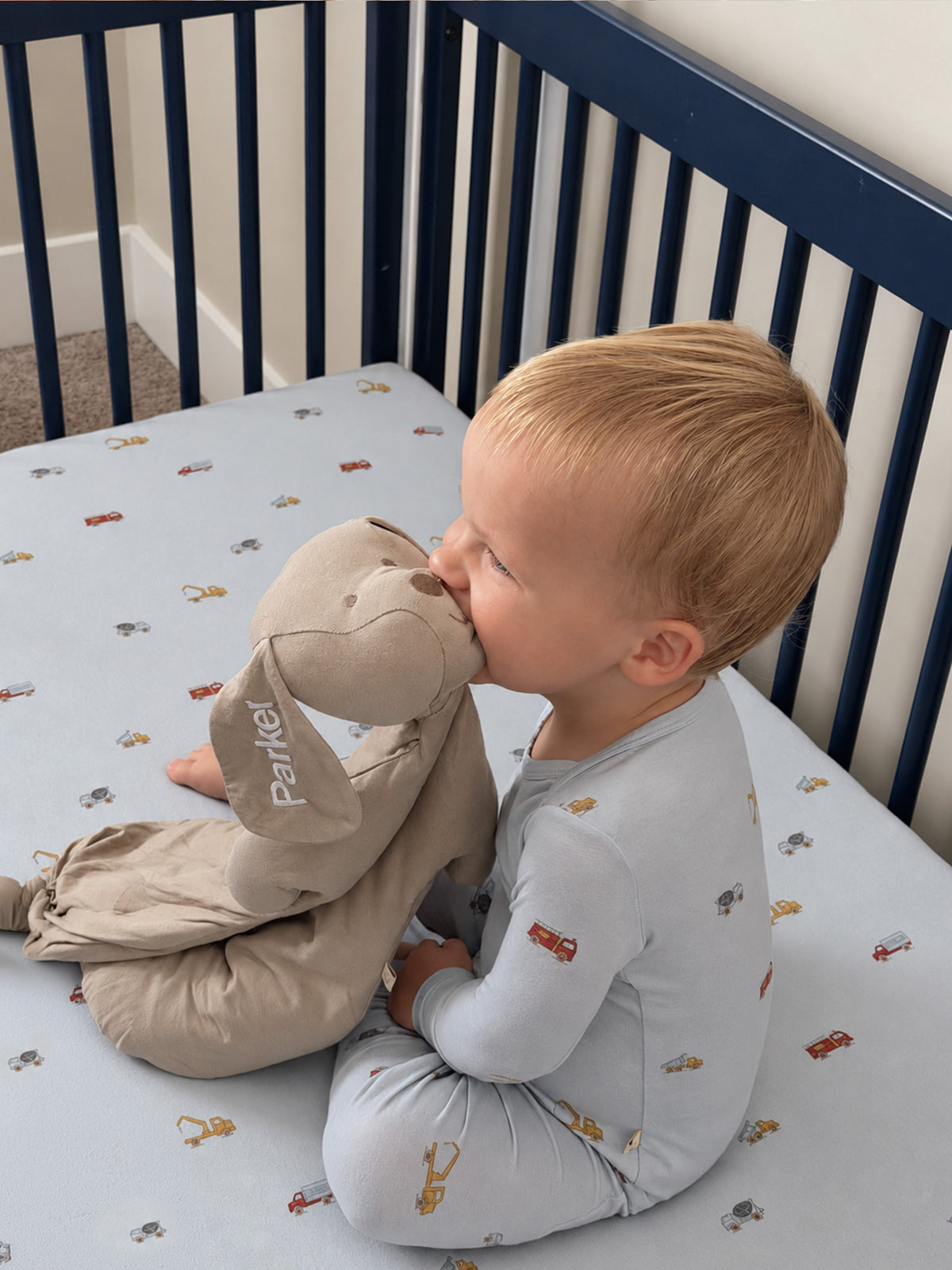 Light gray convertible pajamas with allover vehicle print, long sleeves, child seated view
