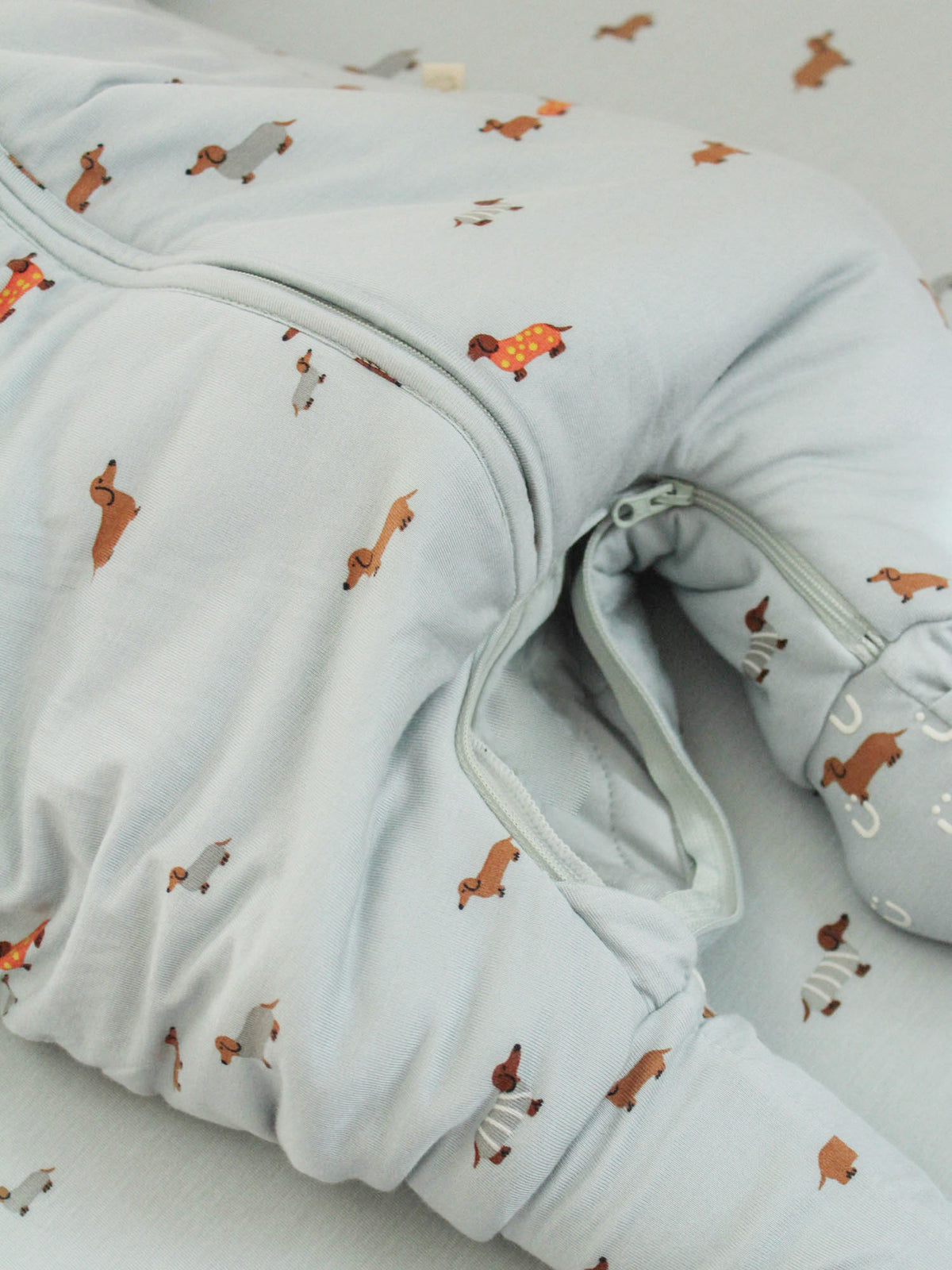 Long-sleeve footie sleep sack with dachshund print, close-up of zipper and leg opening