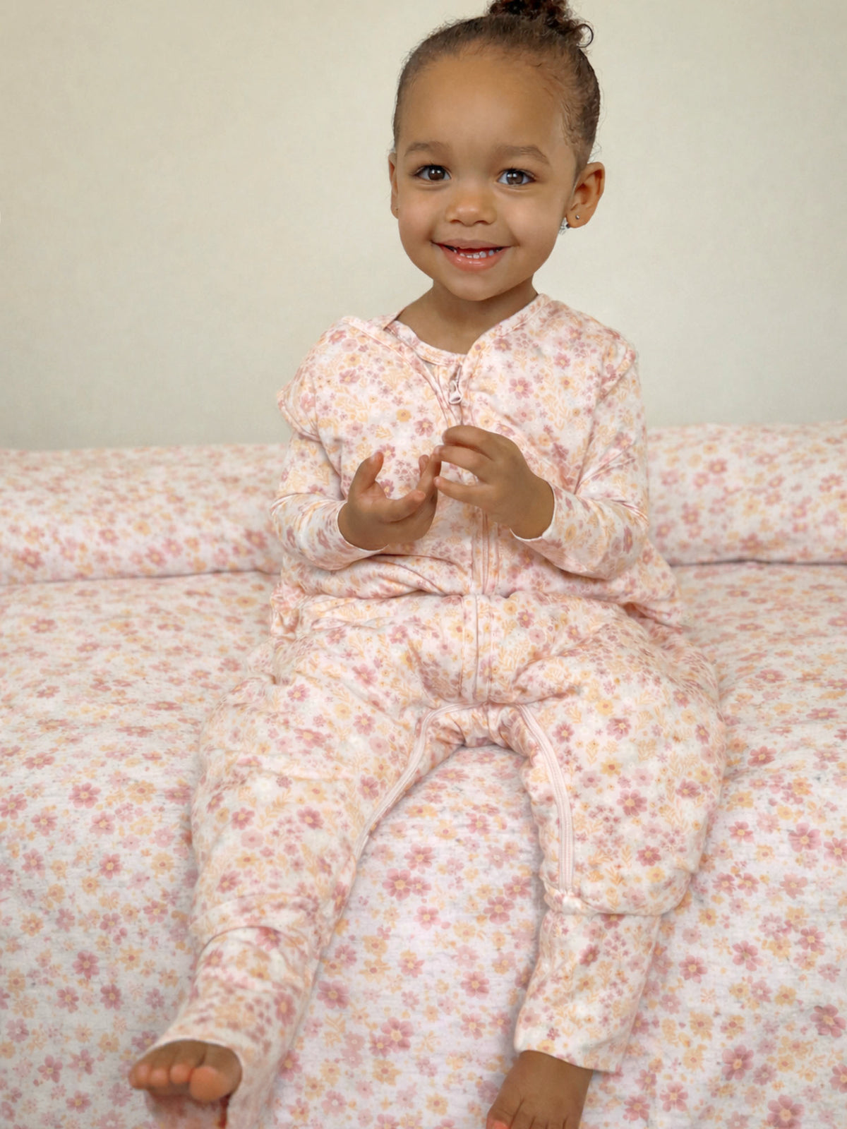Footie sleep sack with pink floral pattern and front zipper, cuffed sleeves and foot openings
