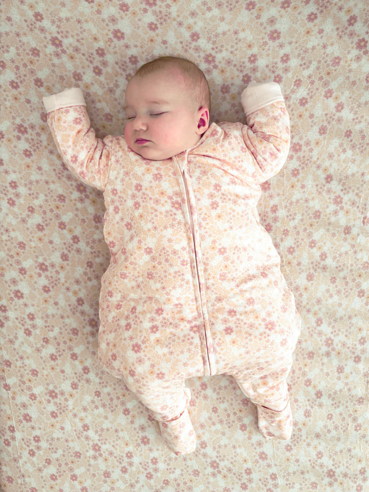 Baby long-sleeve footed sleep sack, pale peach floral pattern, full-length zip