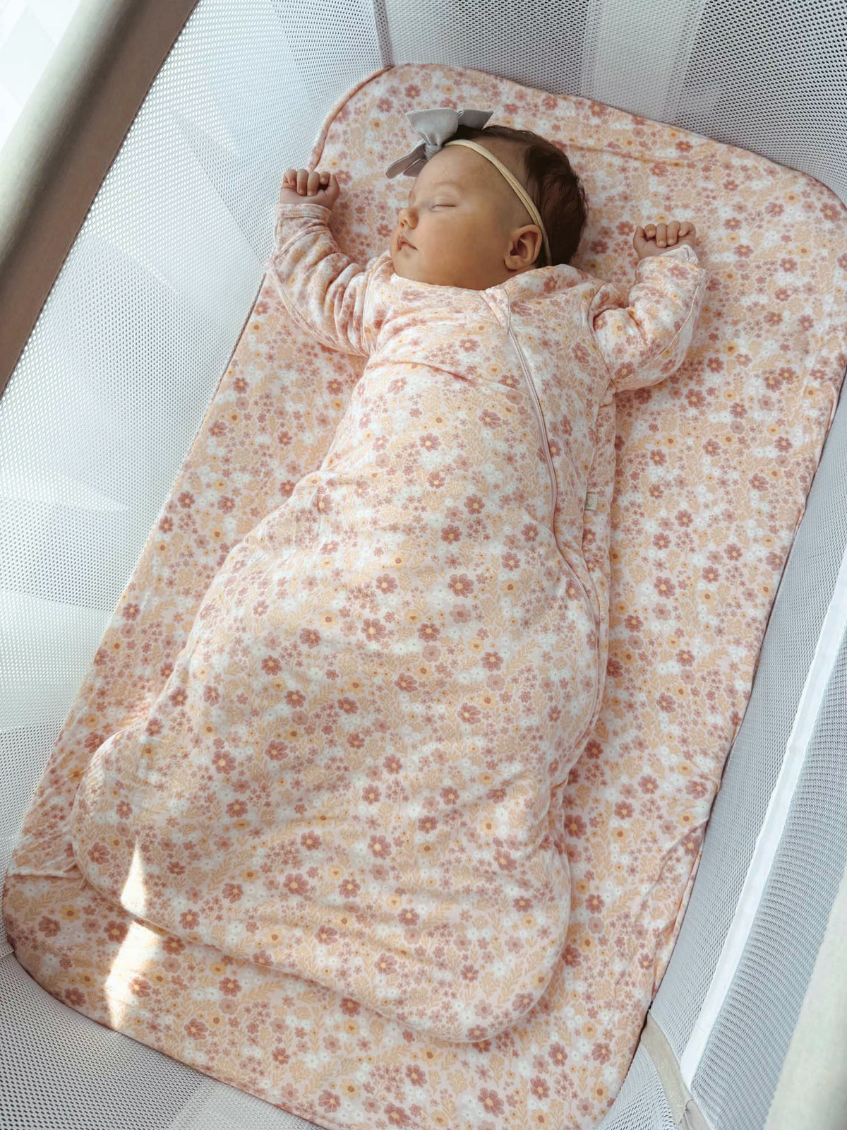 Floral long-sleeve swaddle sleep sack with zipper, soft pink and beige.