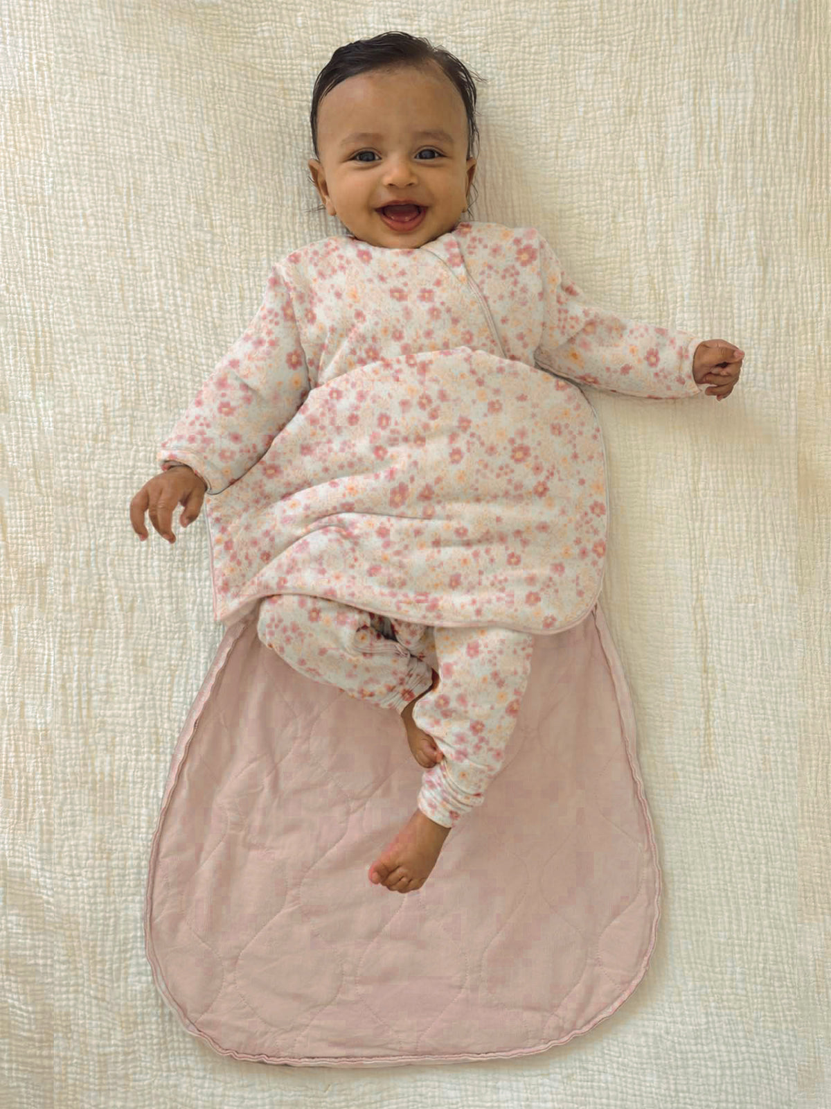 Long-sleeve swaddle sack on baby, light pink floral, open bottom with pouch