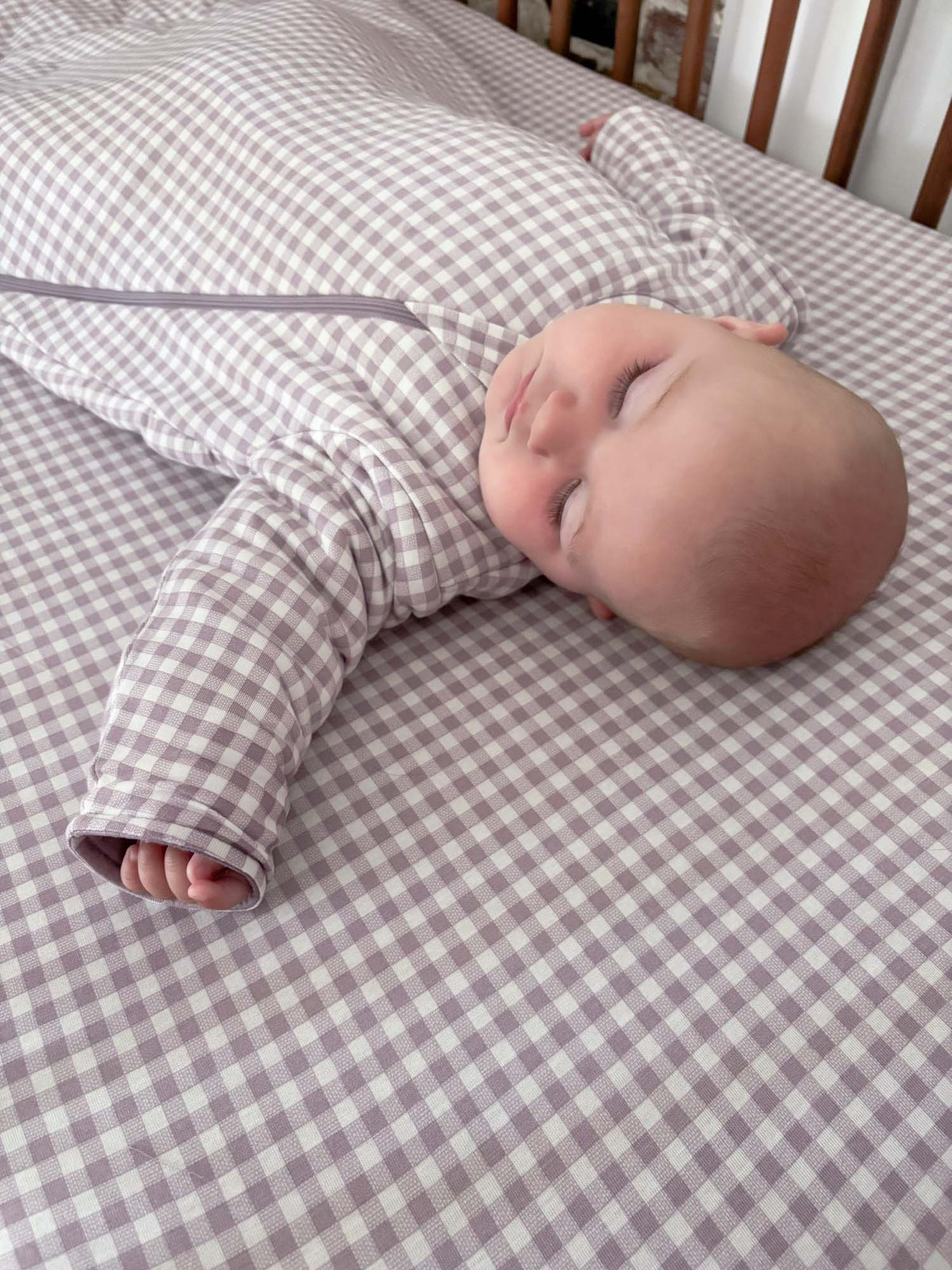 Crib sheet with light purple and white gingham pattern, folded corner detail
