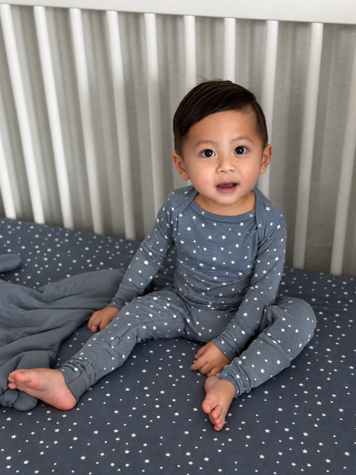 Navy star-print long-sleeve convertible pajama on seated baby