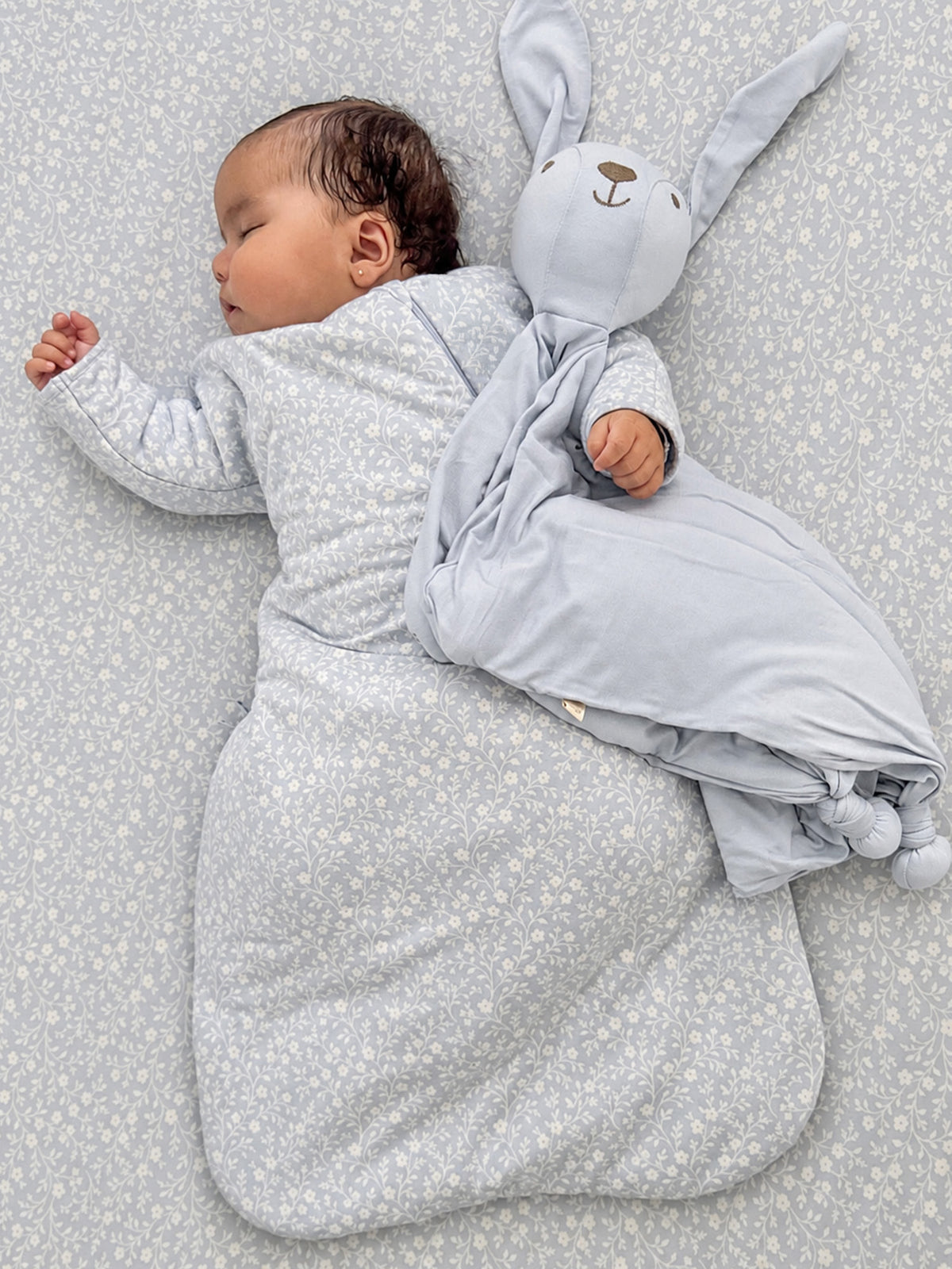 Long-sleeve swaddle sack in light blue with small floral print and bunny hood