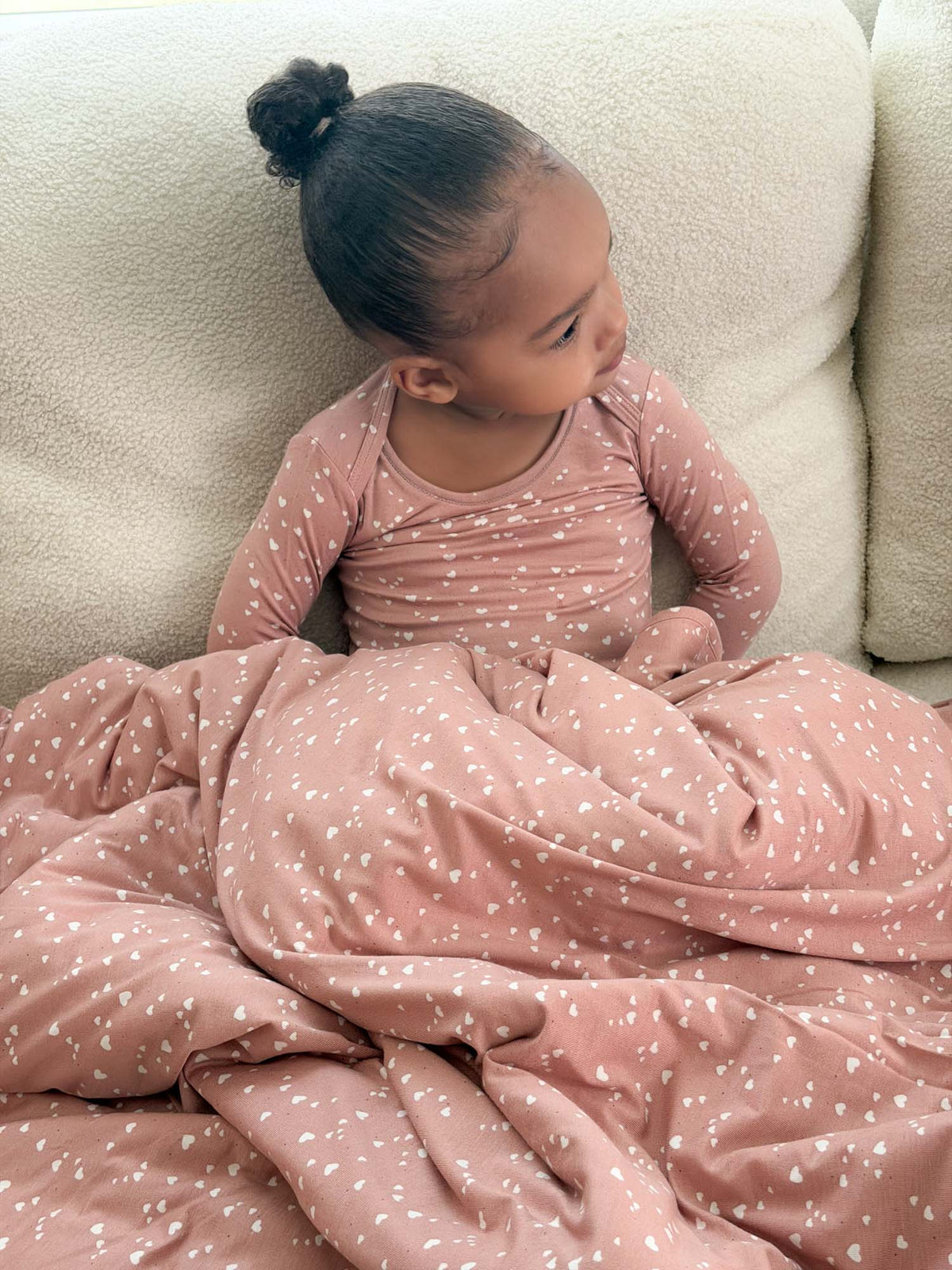 Dusty pink heart-pattern cloud blanket with folded edge, soft plush texture