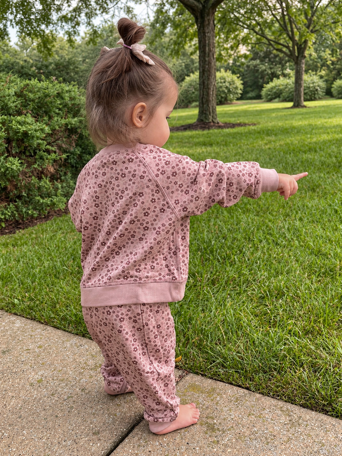 Pink fleece sweatsuit with petal floral print; sweatshirt and pants (standing/walking pose)