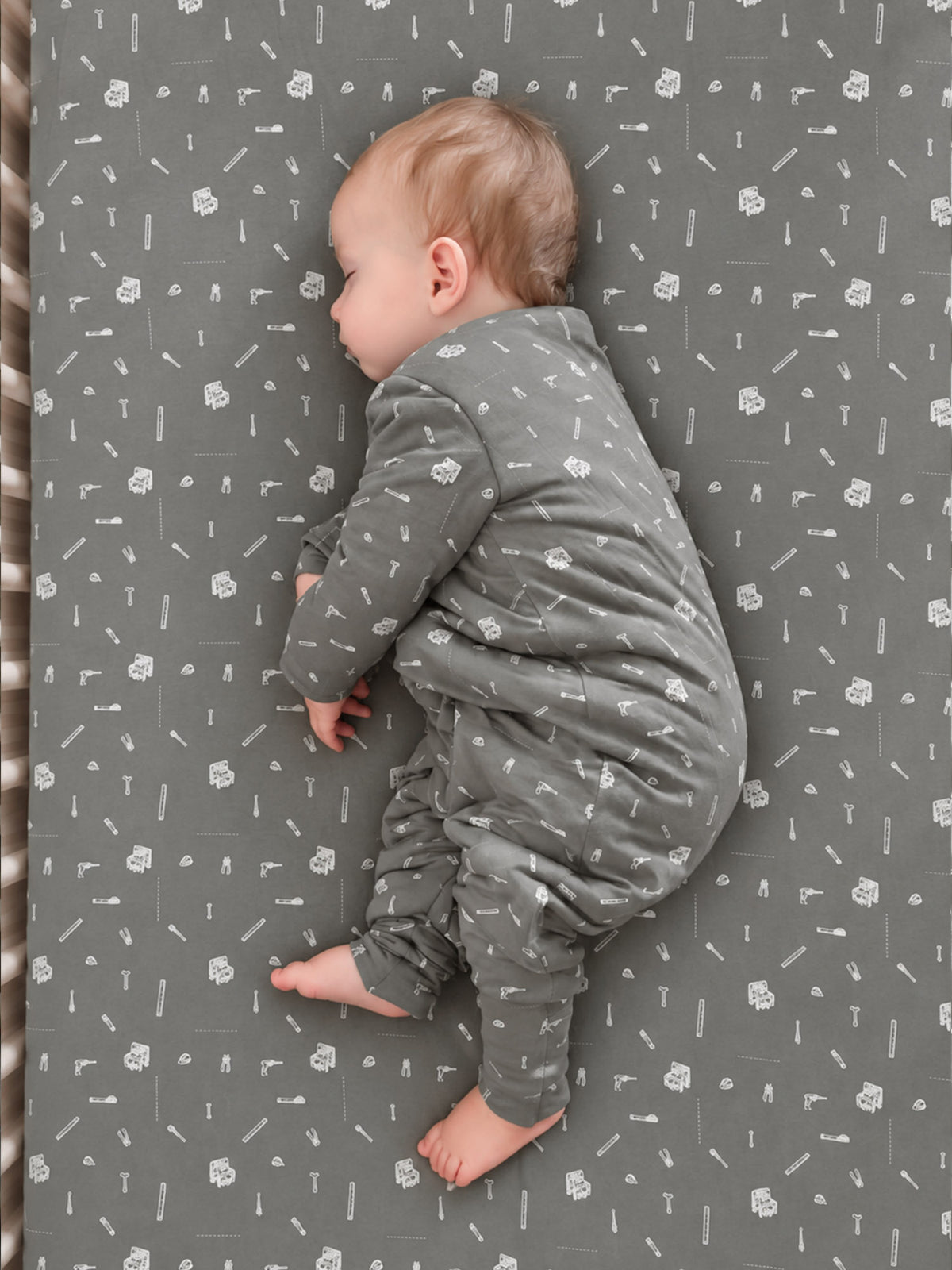 Gray long-sleeve footed sleep sack with white tool icons