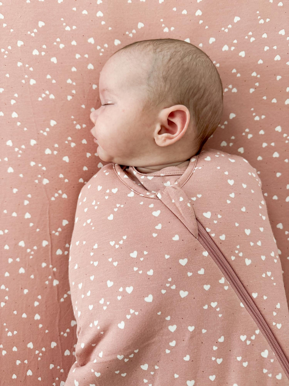 Pink 2.5 tog swaddle sleep sack with white heart print, swaddle wings