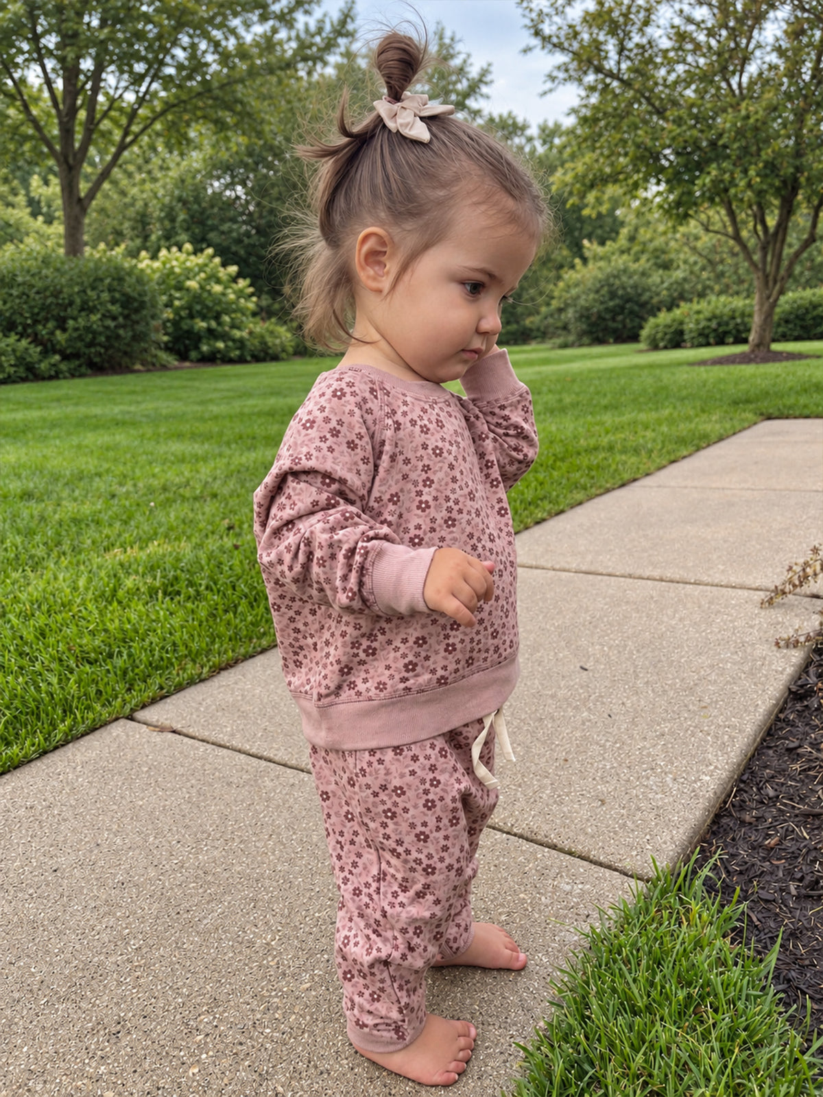 Pink fleece sweatsuit with petal floral print; sweatshirt and pants (side view)