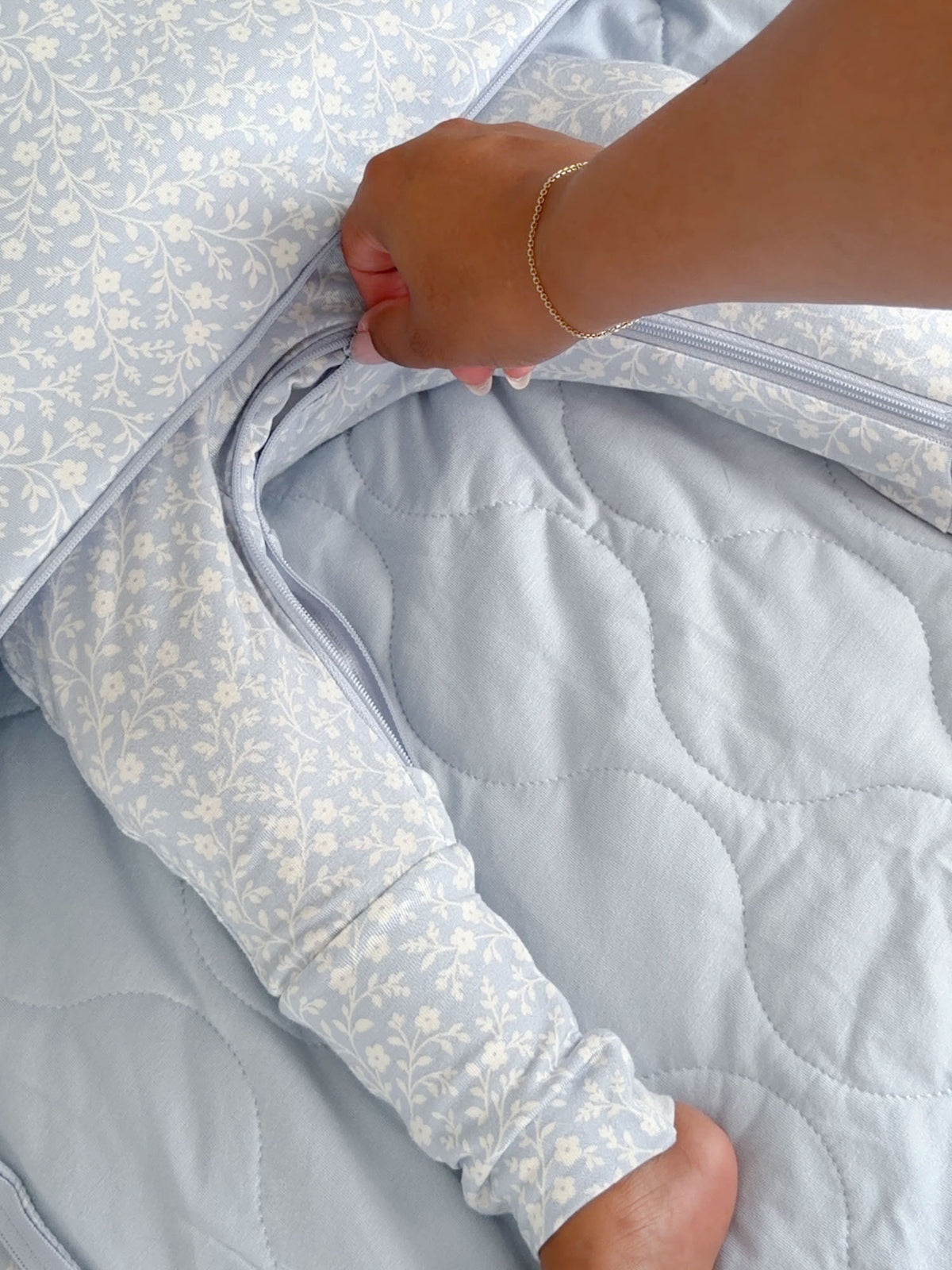 Baby sleep sack detail: light blue floral outer, open zipper and quilted interior lining
