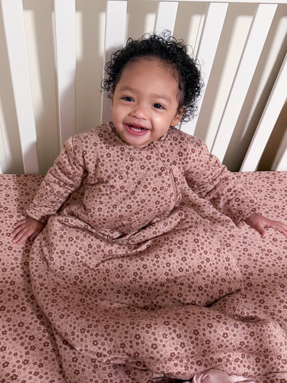 Floral long-sleeve sleep sack, light pink petal print, toddler seated