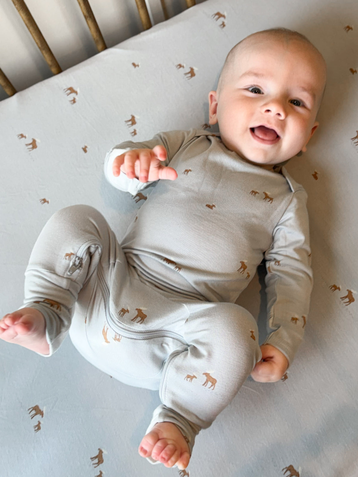 Light gray long-sleeve baby pajama set with small moose print and ankle cuffs
