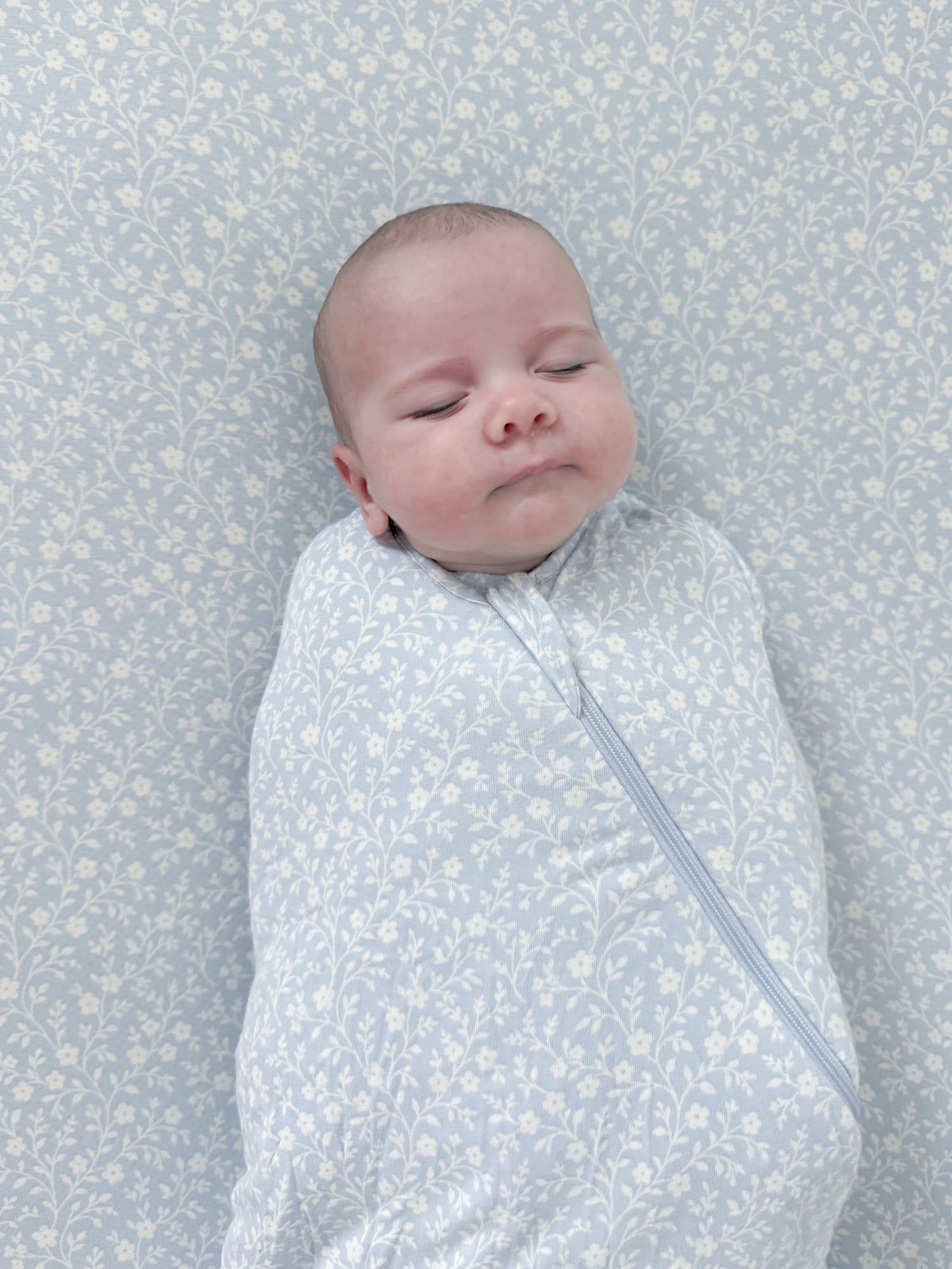 Light blue floral swaddle sleep sack with front zipper and hooded collar