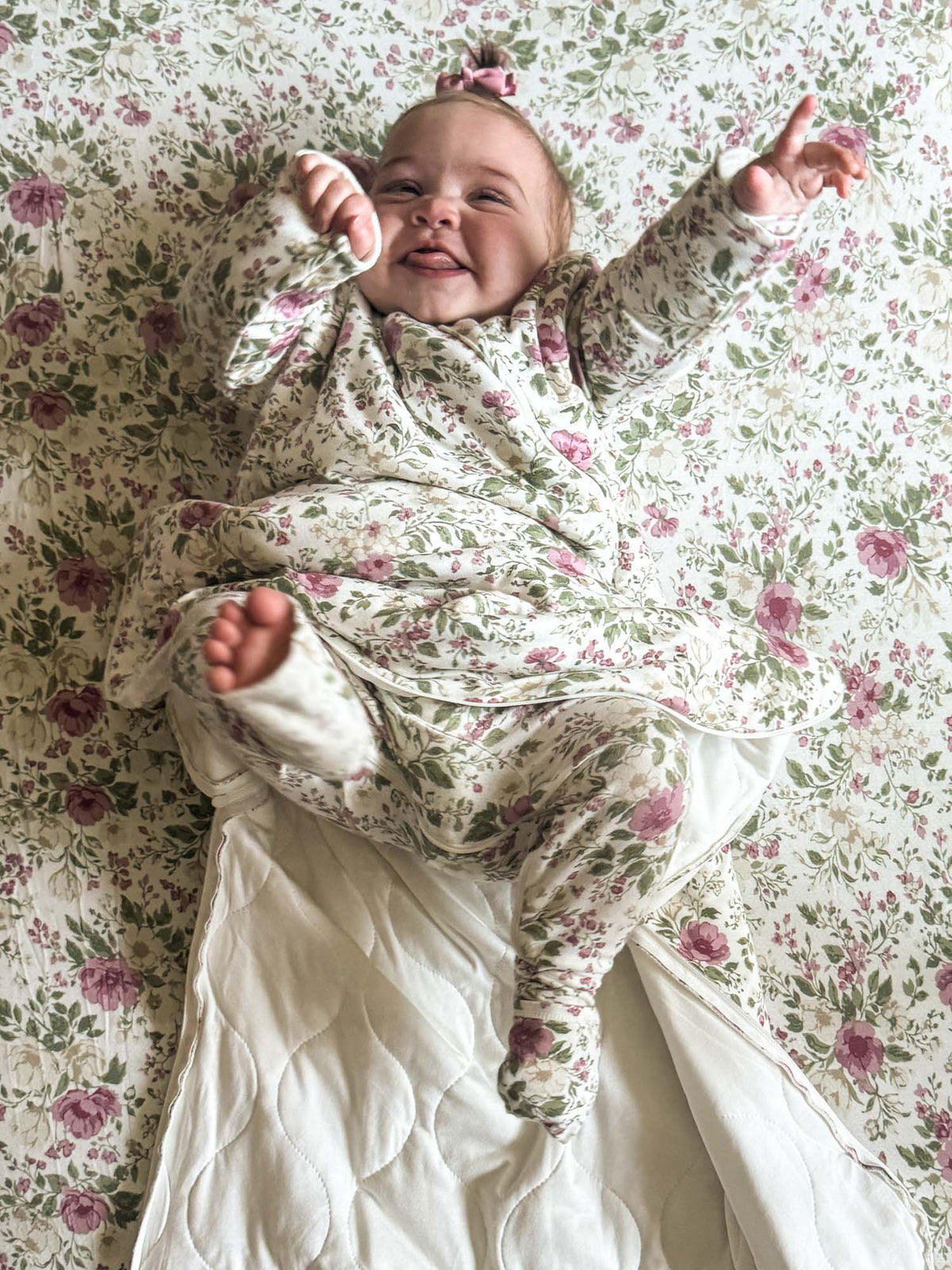 Long-sleeve floral sleep sack with pink rose pattern, worn with hood