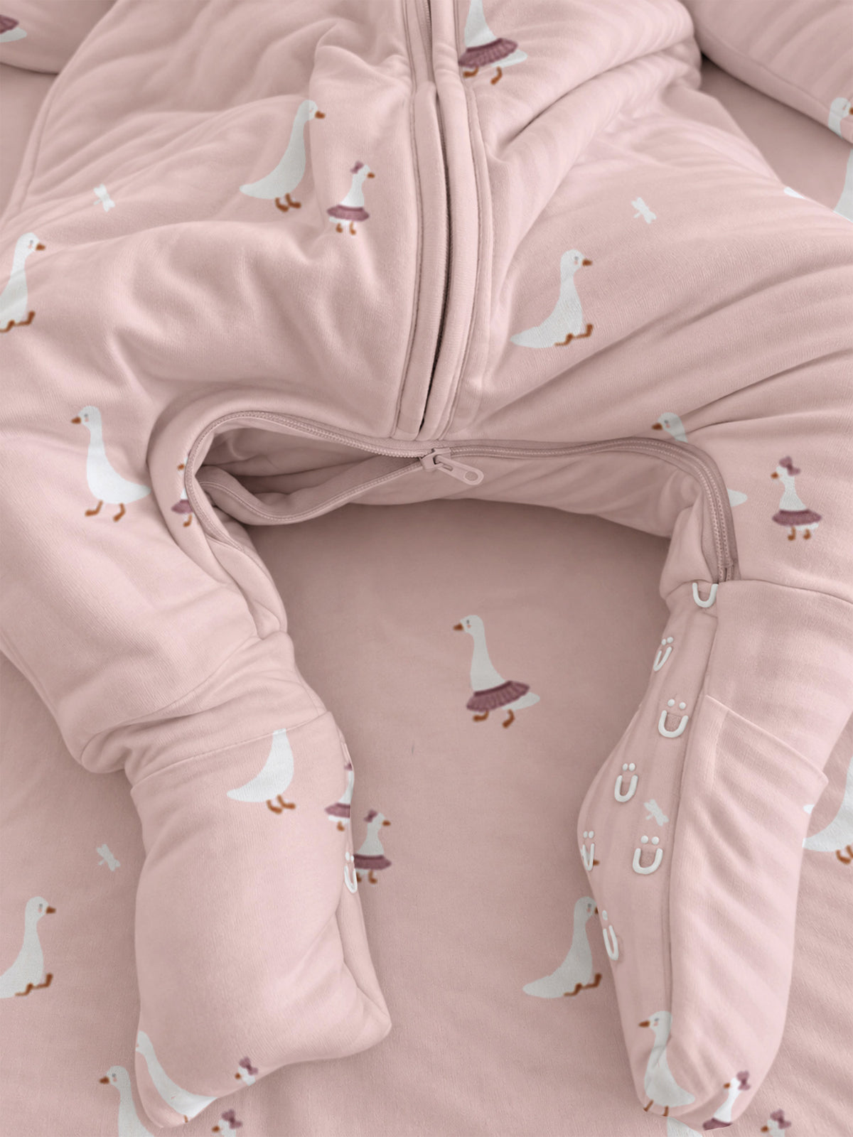 Pink footie sleep sack close-up with goose print and zip-front opening