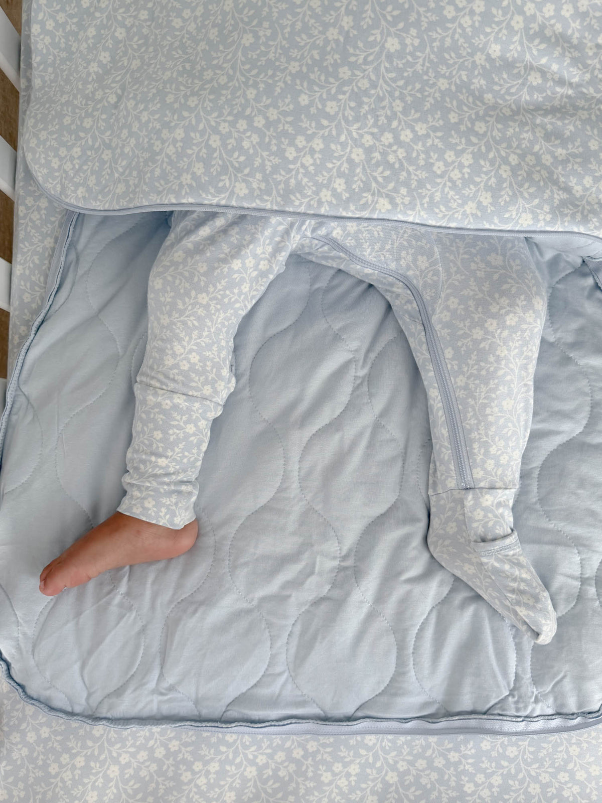 Meadow sleep sack with open bottom flap, long sleeves, quilted light blue interior