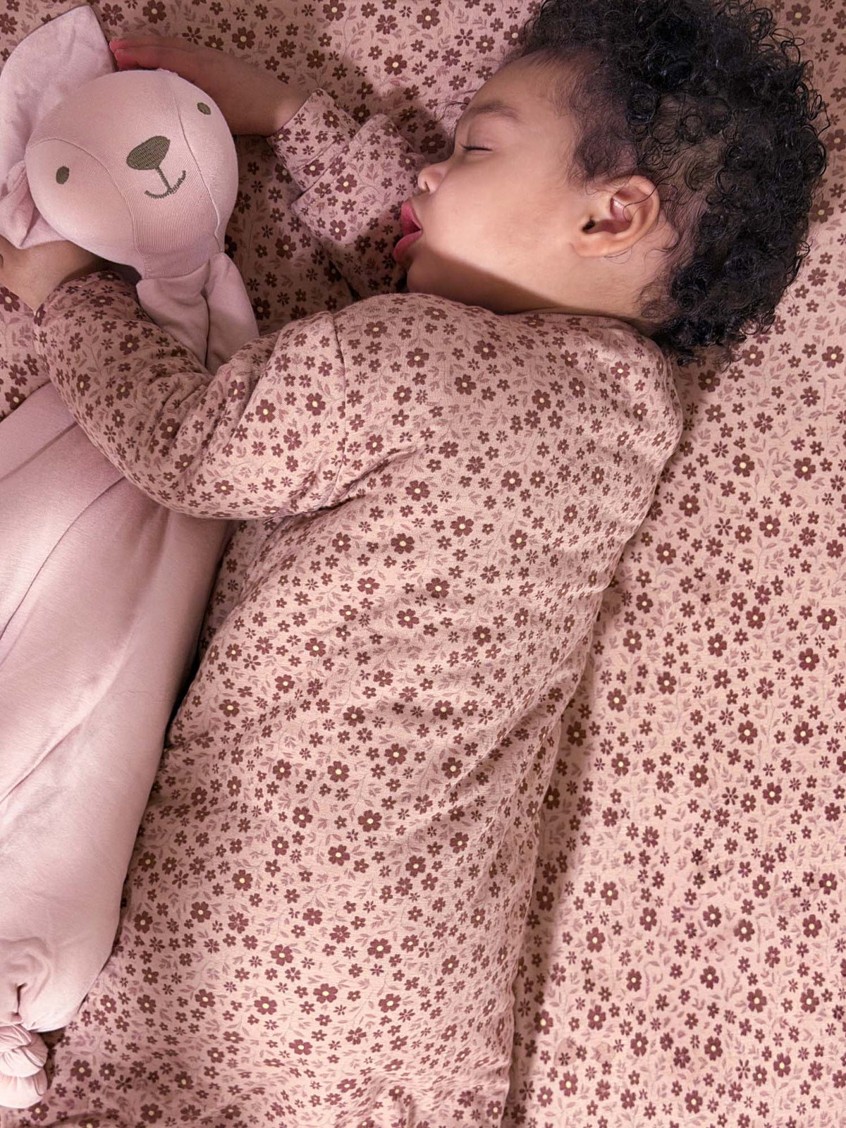 Floral long-sleeve sleep sack in light pink with small petal print, footed