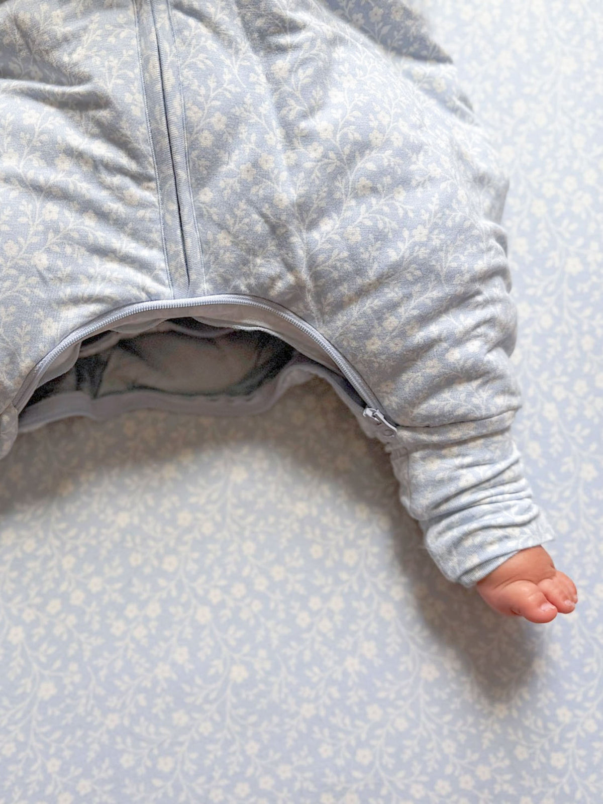 Light blue footie sleep sack with tiny pattern and zip front, open leg with cuff