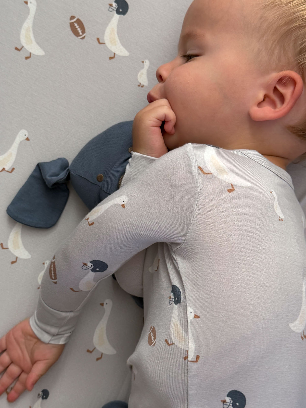 Light gray crib sheet with white goose and football pattern