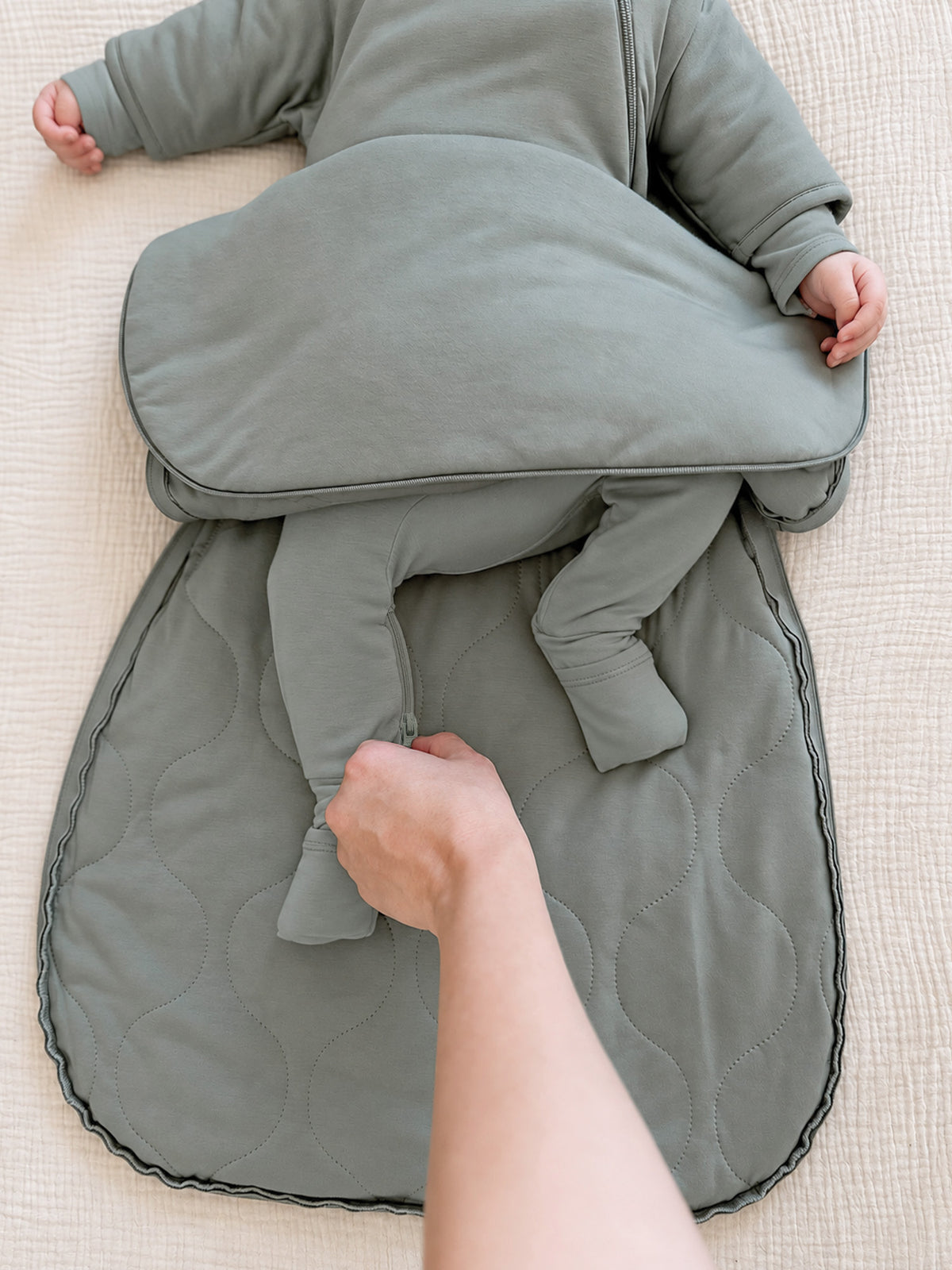 Sage green swaddle sack close-up of arm openings and gathered lower fabric