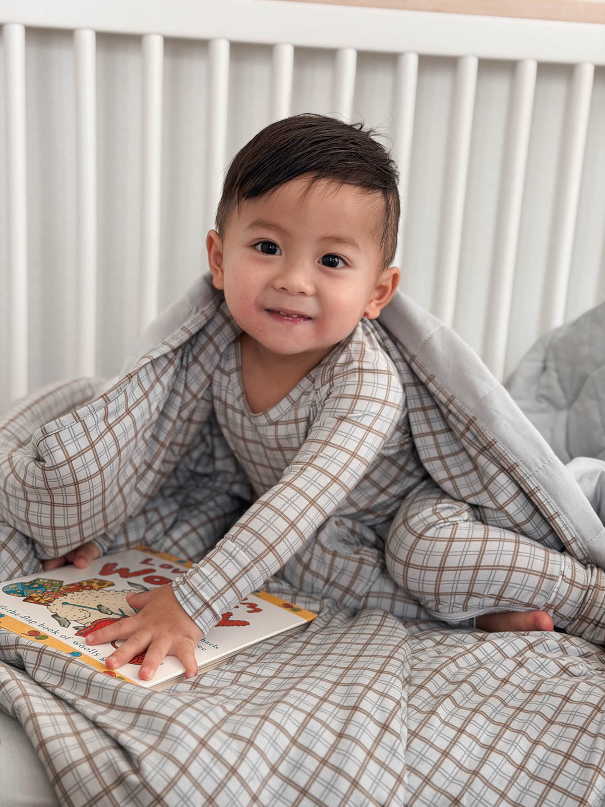 Plaid quilted baby blanket in gray and cream checks, with stitched, gathered border