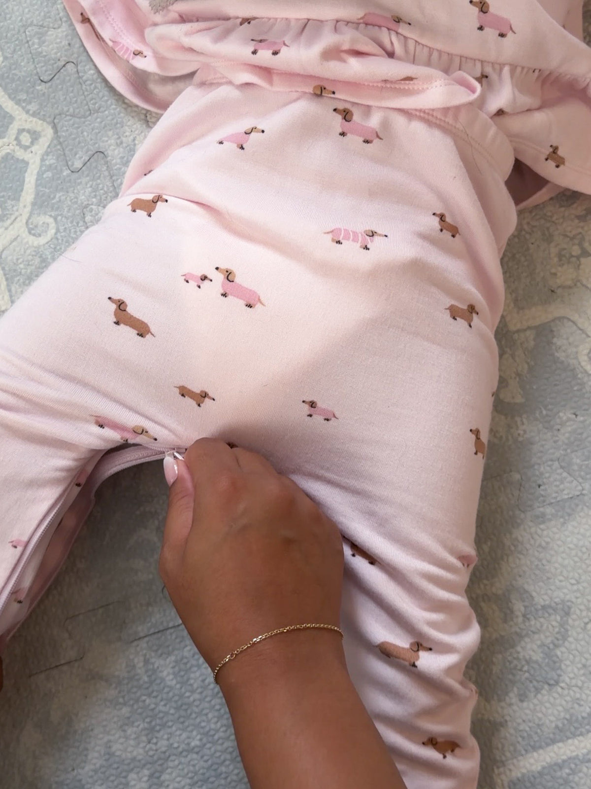 Pale pink fleece pants with allover dog print, elastic waistband and ruffle hem