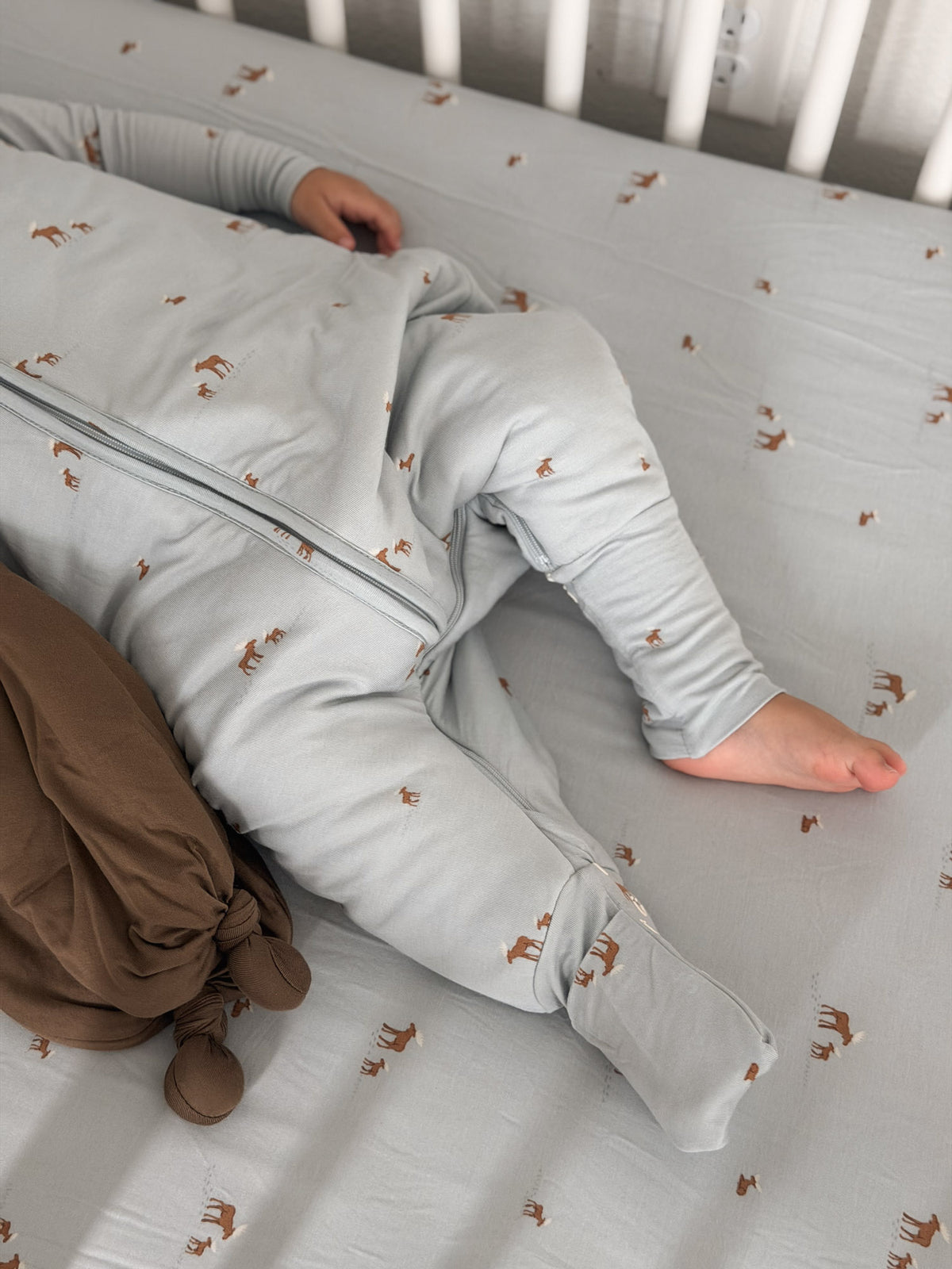 Light gray footie sleep sack with orange moose print and zipper, open leg detail
