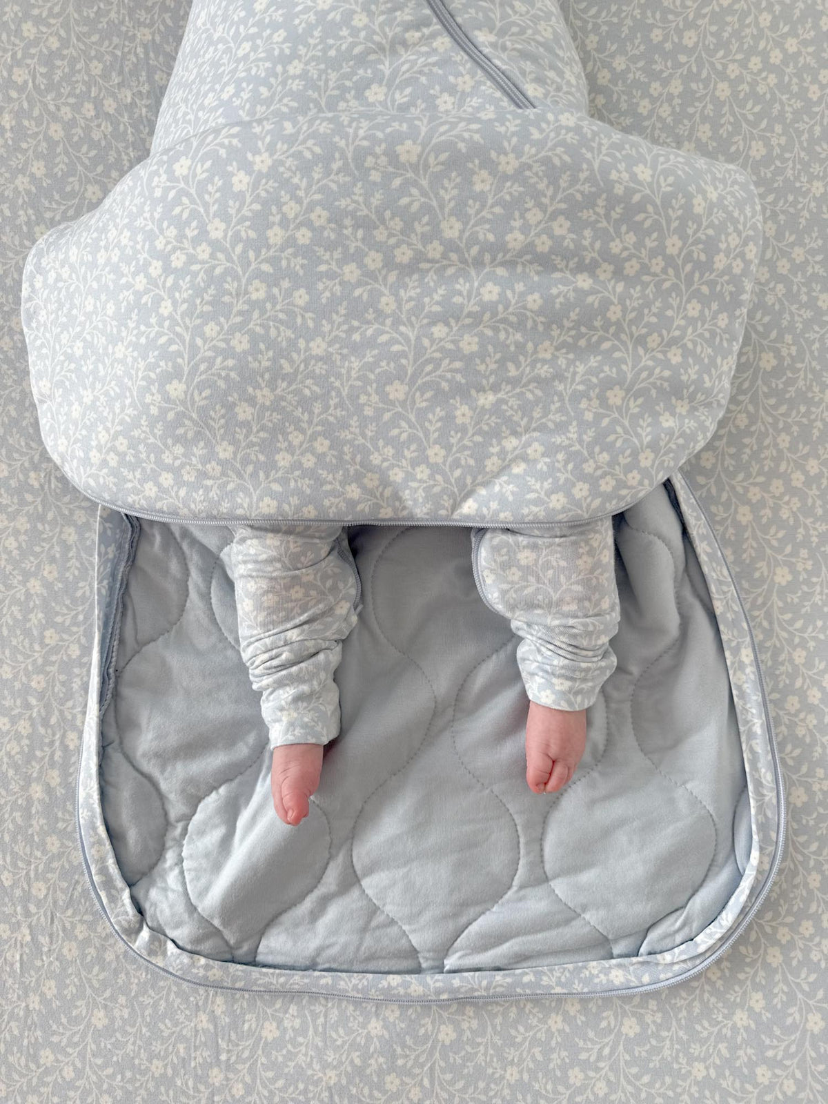 Light blue floral sleep sack with inner gray lining and swaddle wing design