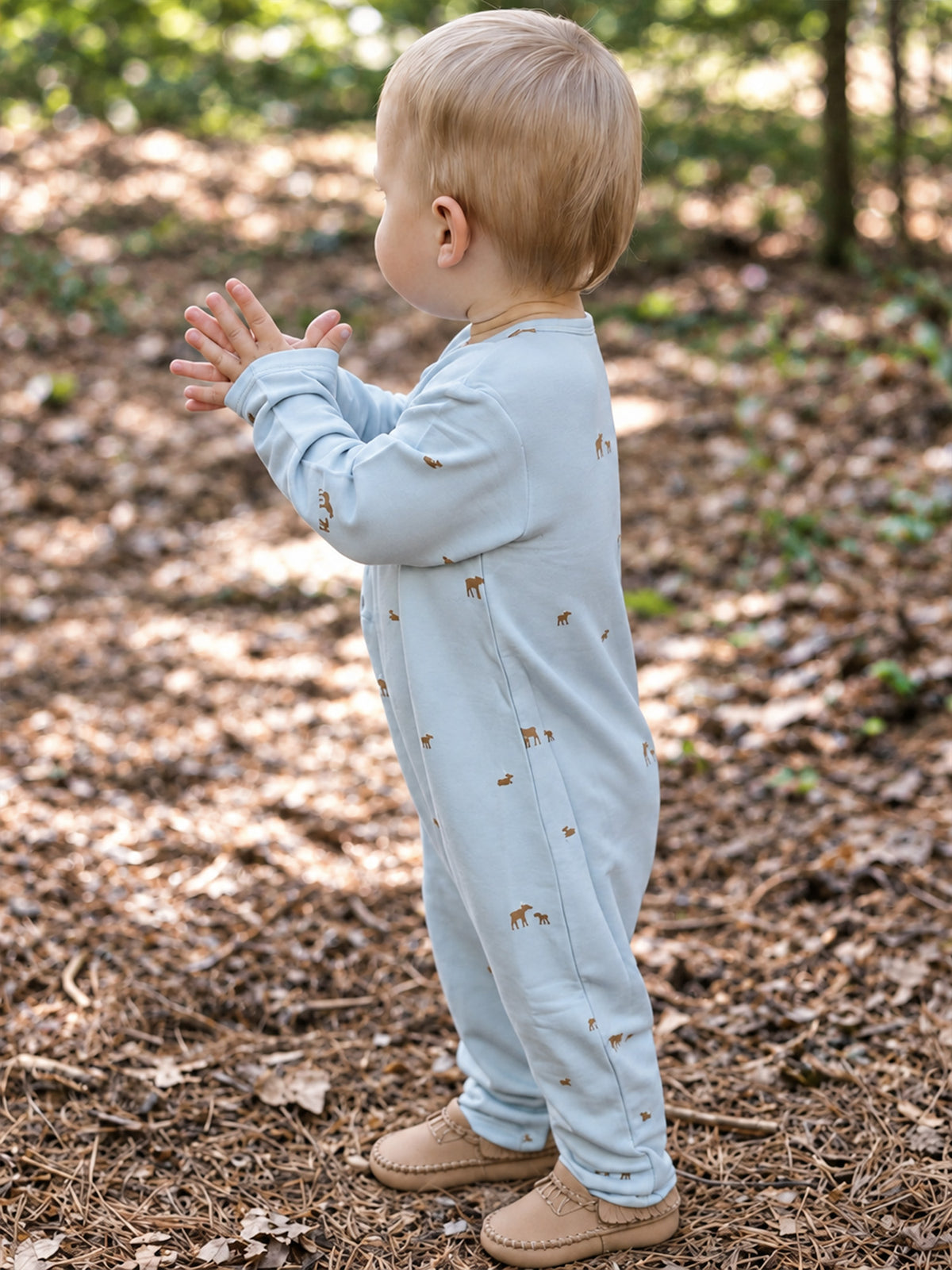 Light blue baby henley jumpsuit with long sleeves and allover moose print, full body side